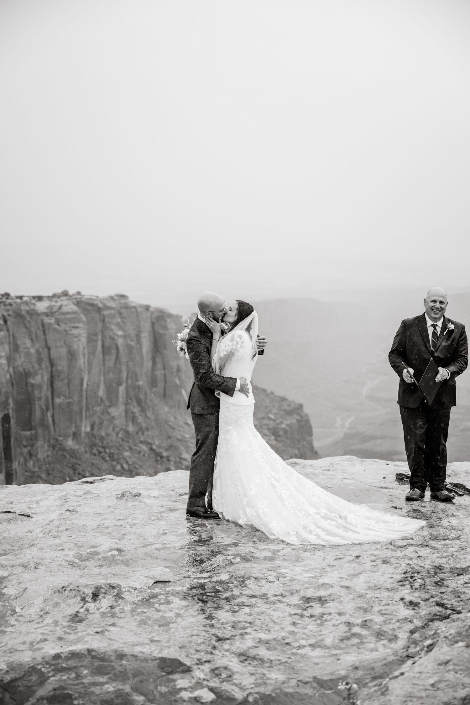 Black and white wedding photos captured on dramatic cliffs with flowing white dress.