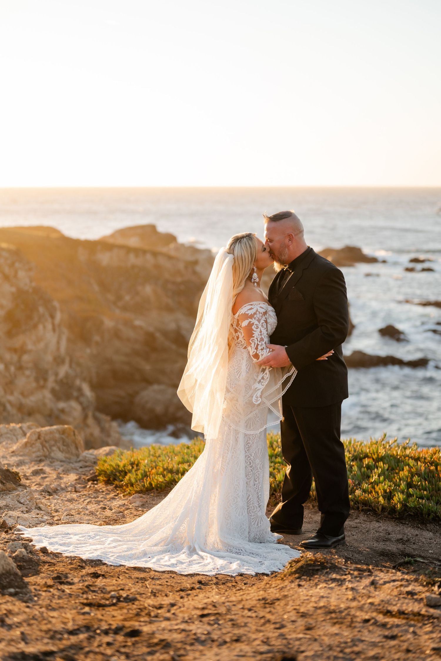 A golden hour wedding photography session on dramatic coastal cliffs overlooking the ocean.