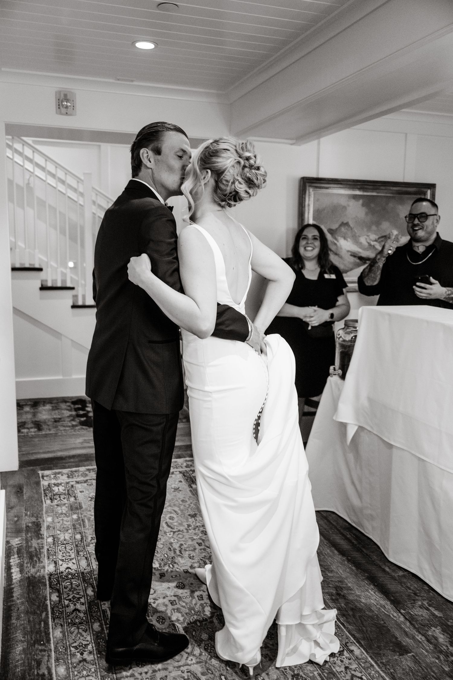 A black and white photo captures a couple's first dance at their wedding reception.