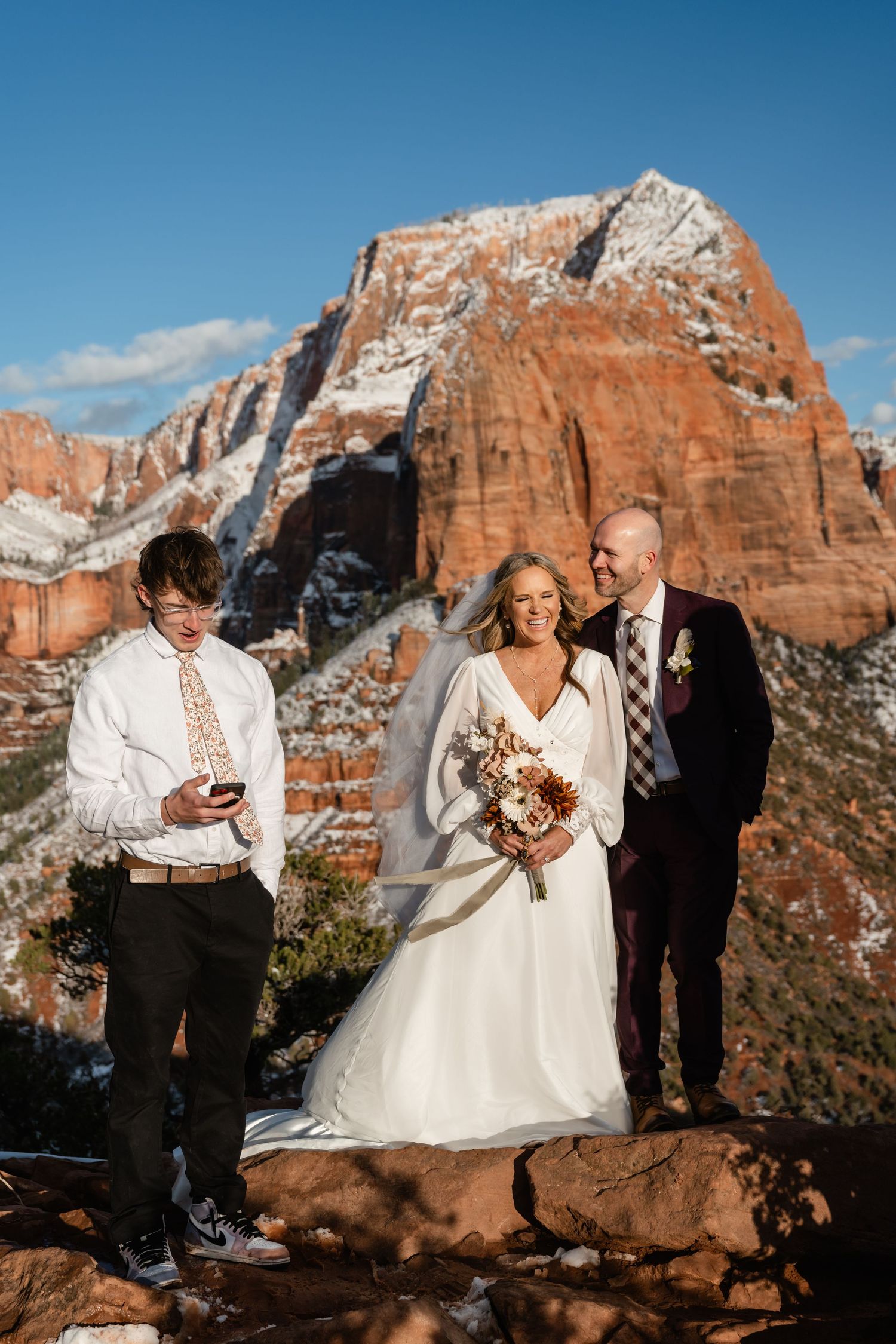 Wedding ceremony with dramatic red rock canyon backdrop in Zion National Park.
