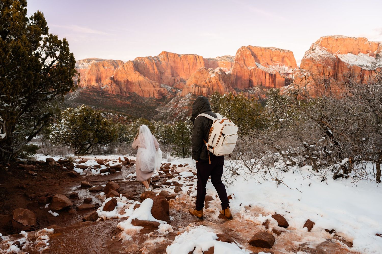 Winter wedding photos with snow-covered red rock formations at sunset.