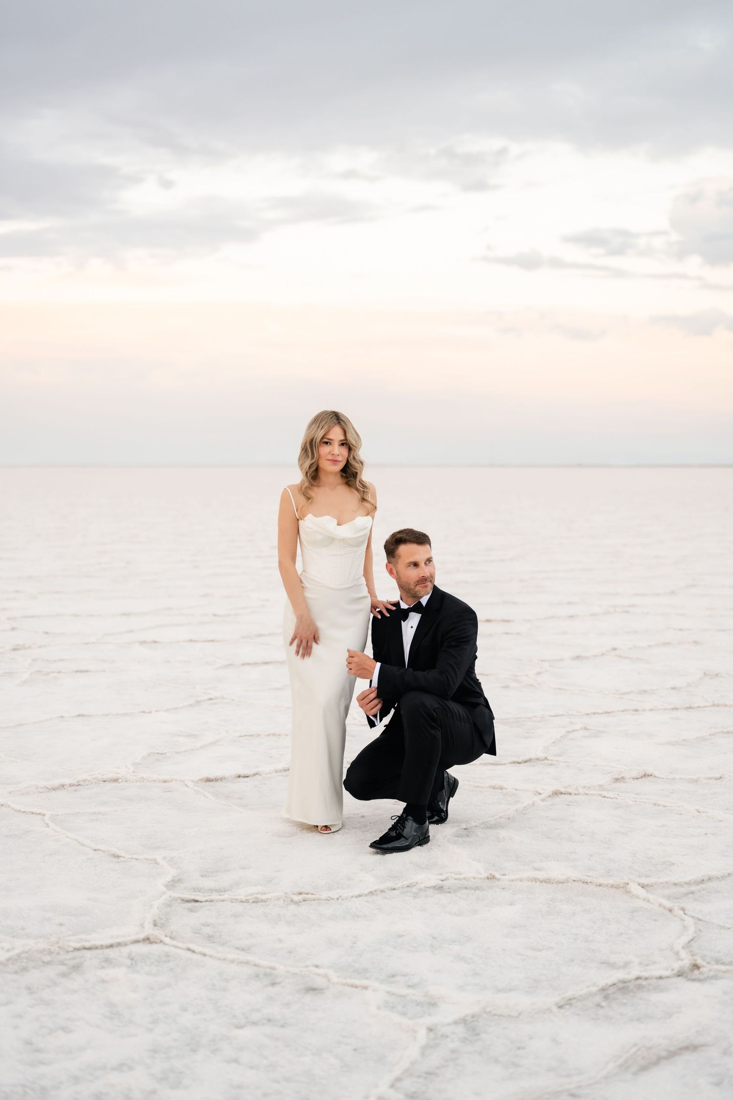 Salt Flats Elopement Photographer. Wedding couple poses artistically on the pristine white surface of a salt flat at sunset.