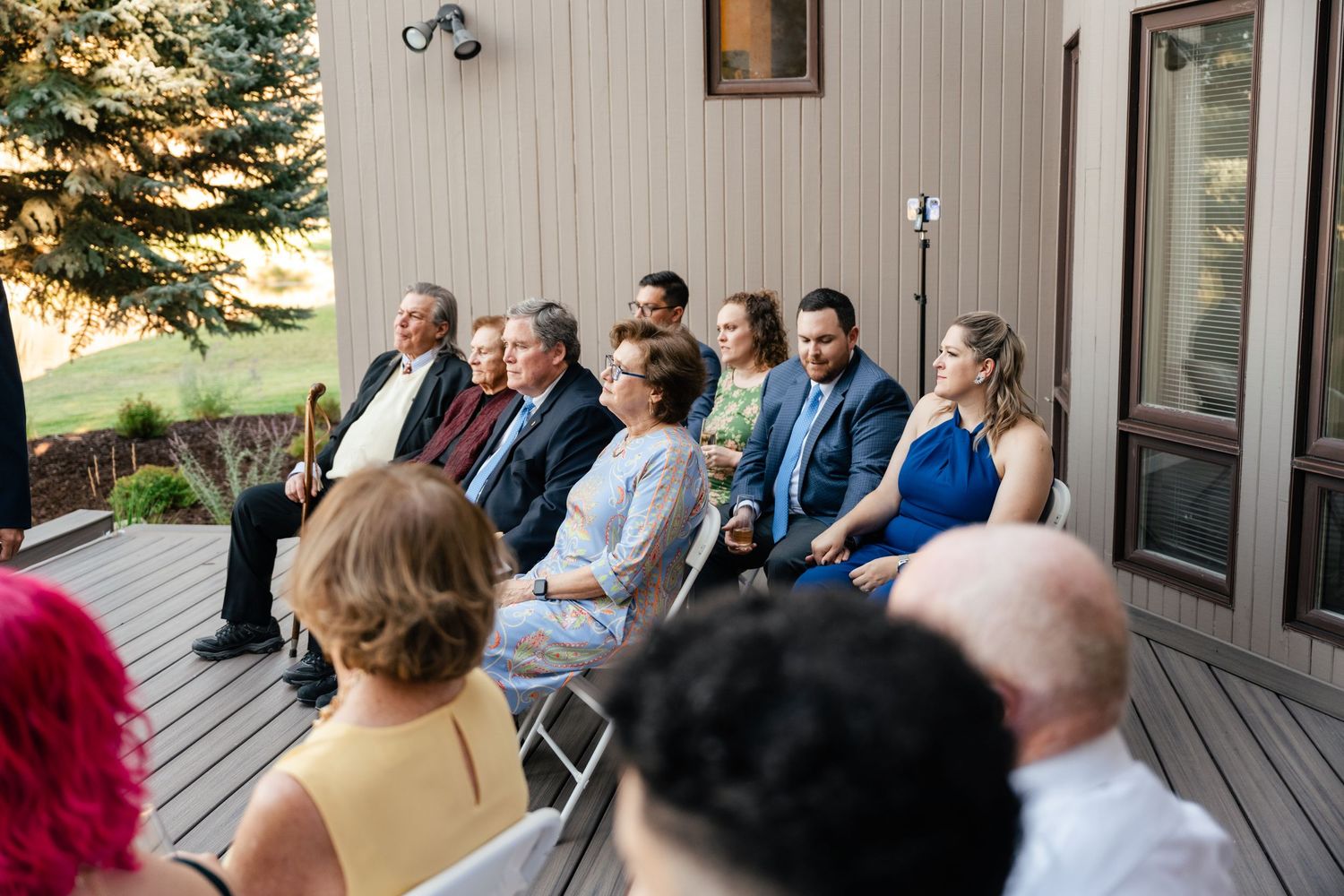 Wedding guests seated in rows on a deck during an outdoor ceremony.