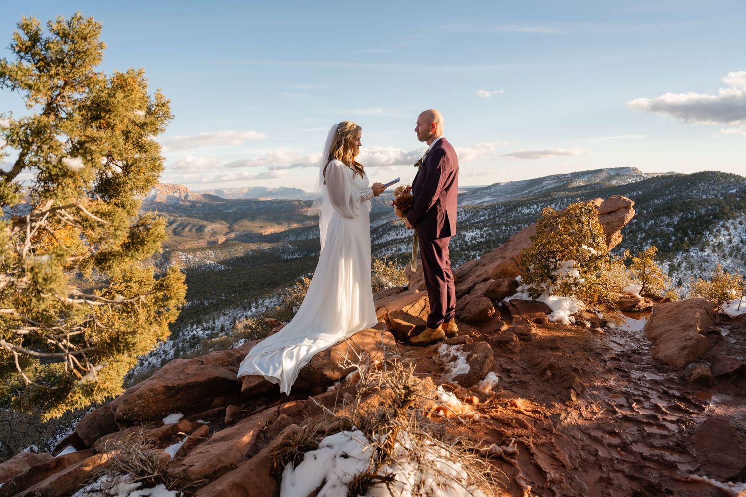 Sunset wedding photography session on a rocky mountain overlook with golden light.