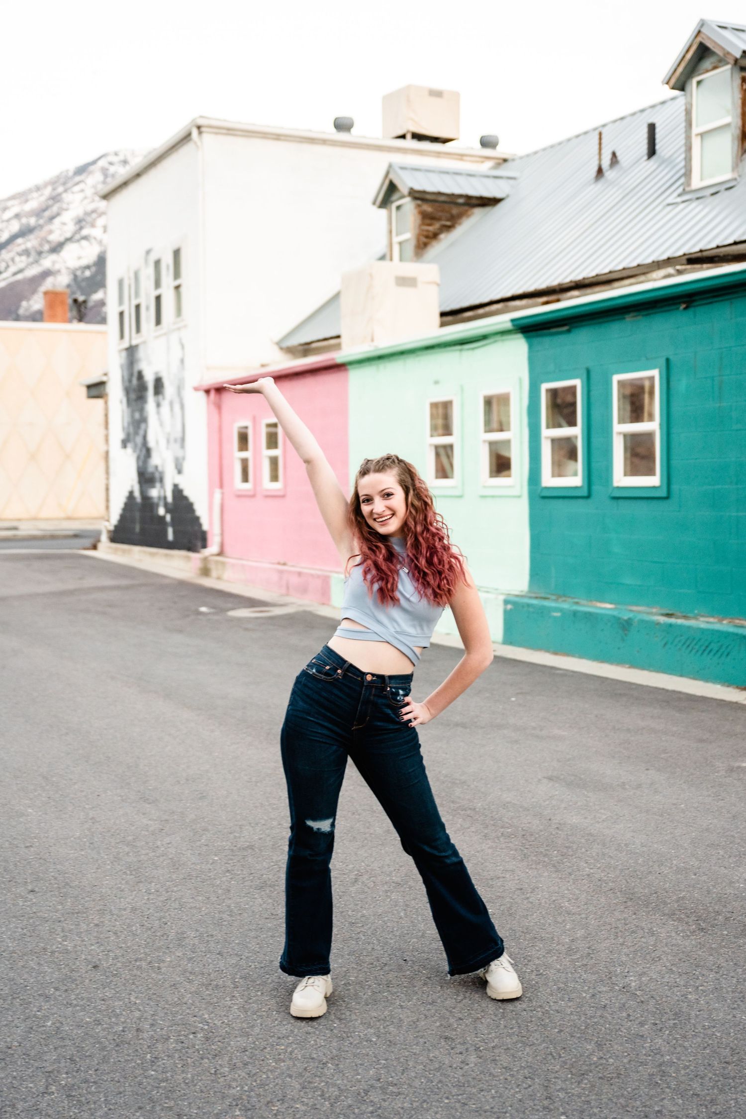 A sequence of dance poses on a street with colorful buildings in the background.