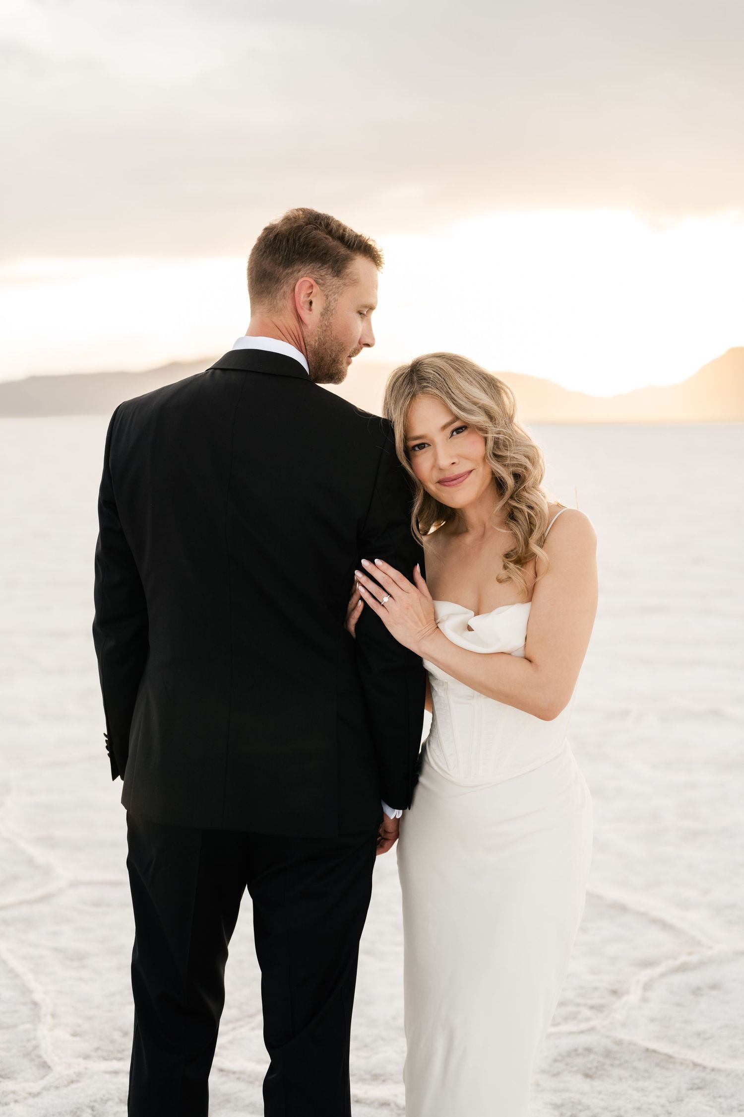 Salt Flats Elopement Photographer. A couple shares intimate moments during their wedding photoshoot on salt flats at sunset.