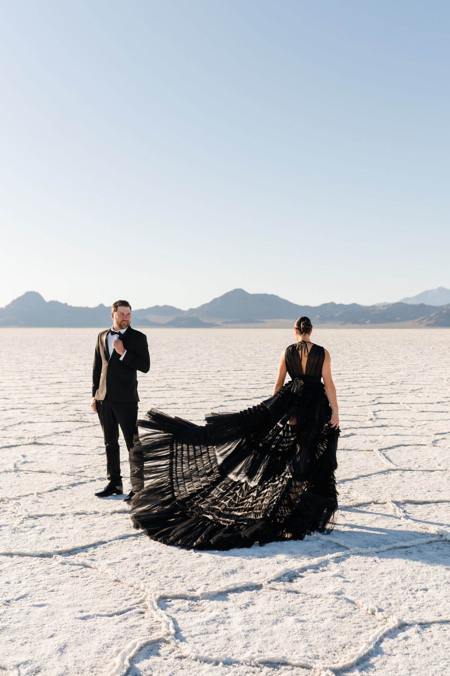 Salt Flats Photographer. A dramatic photoshoot on salt flats featuring a flowing black dress against the white landscape.