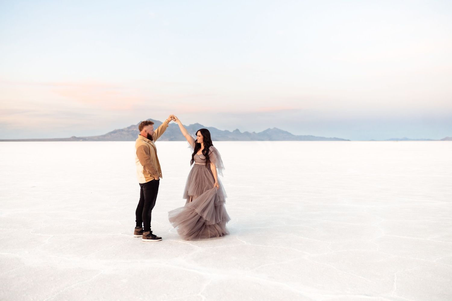 Couple dances on the Salt Flats during their photoshoot by Utah Wedding Photographer