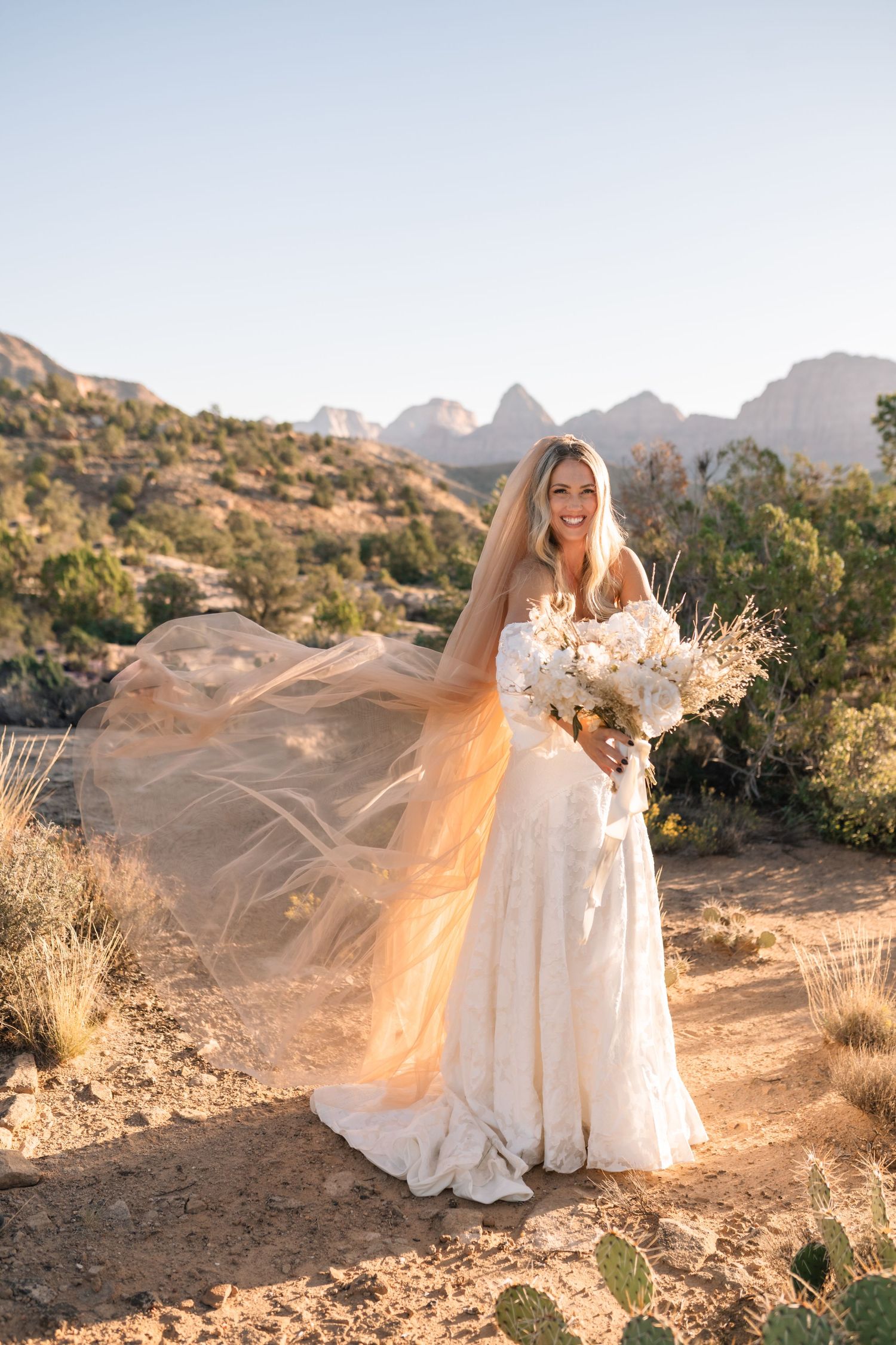 Zions wedding photographer takes beautiful desert sunrise bridals featuring a unique veil and dried floral bouquet.