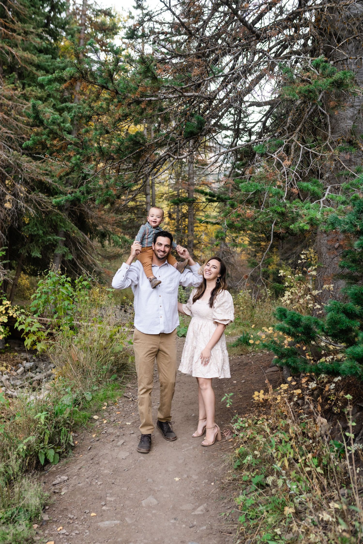 Family walking together on mountain trail during outdoor photo session.