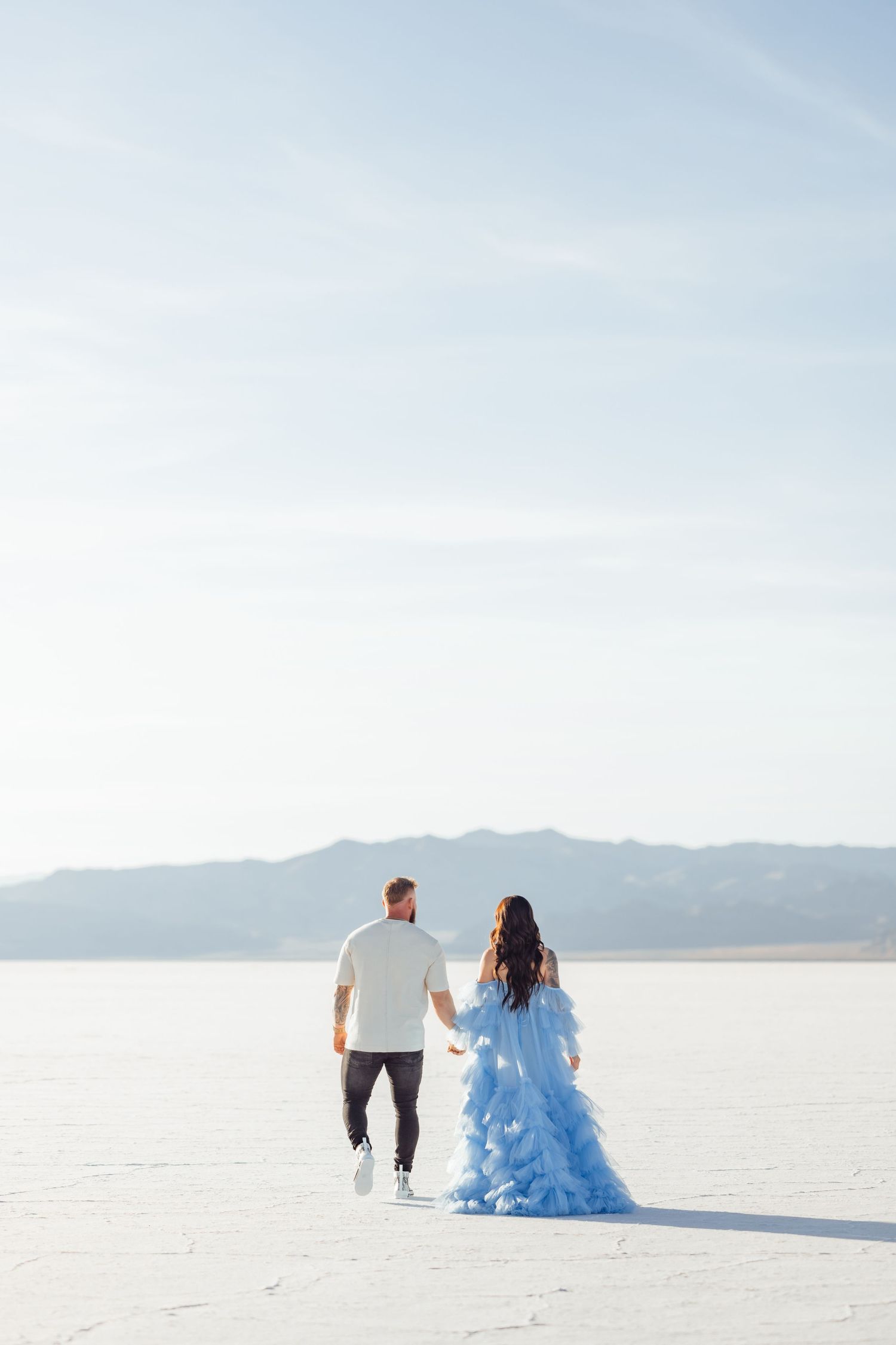 Couple holds hands during golden hour at the Salt Flats by Utah Salt Flats photographer