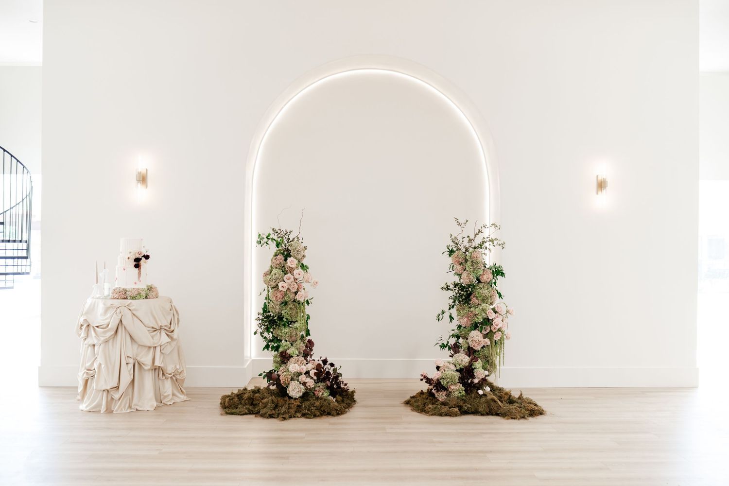 Elegant broken floral arch in front of built in archway creates an intimate wedding reception setting. Utah Wedding Photographer and Video.