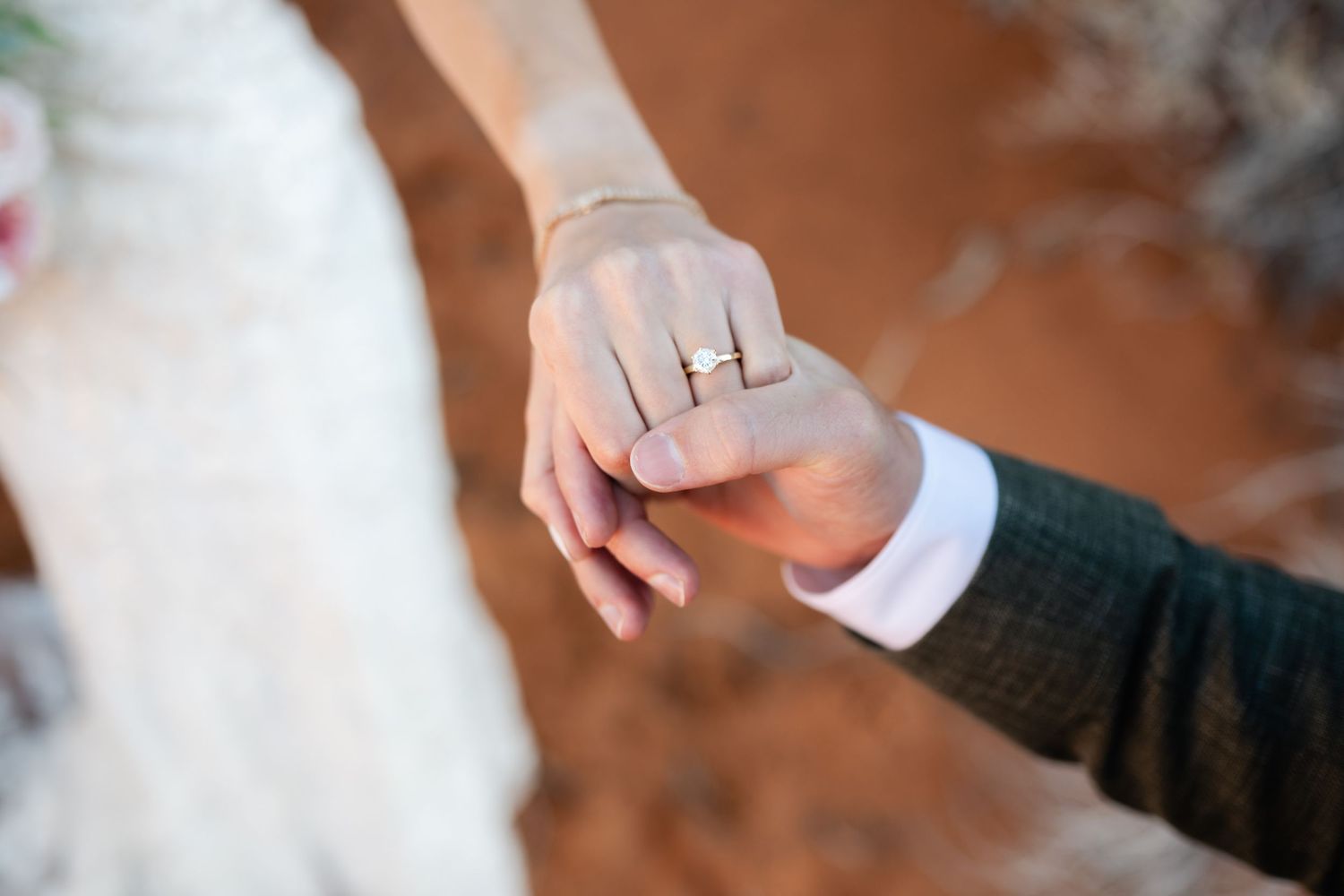 Close-up view of hands exchanging wedding rings during an intimate ceremony.