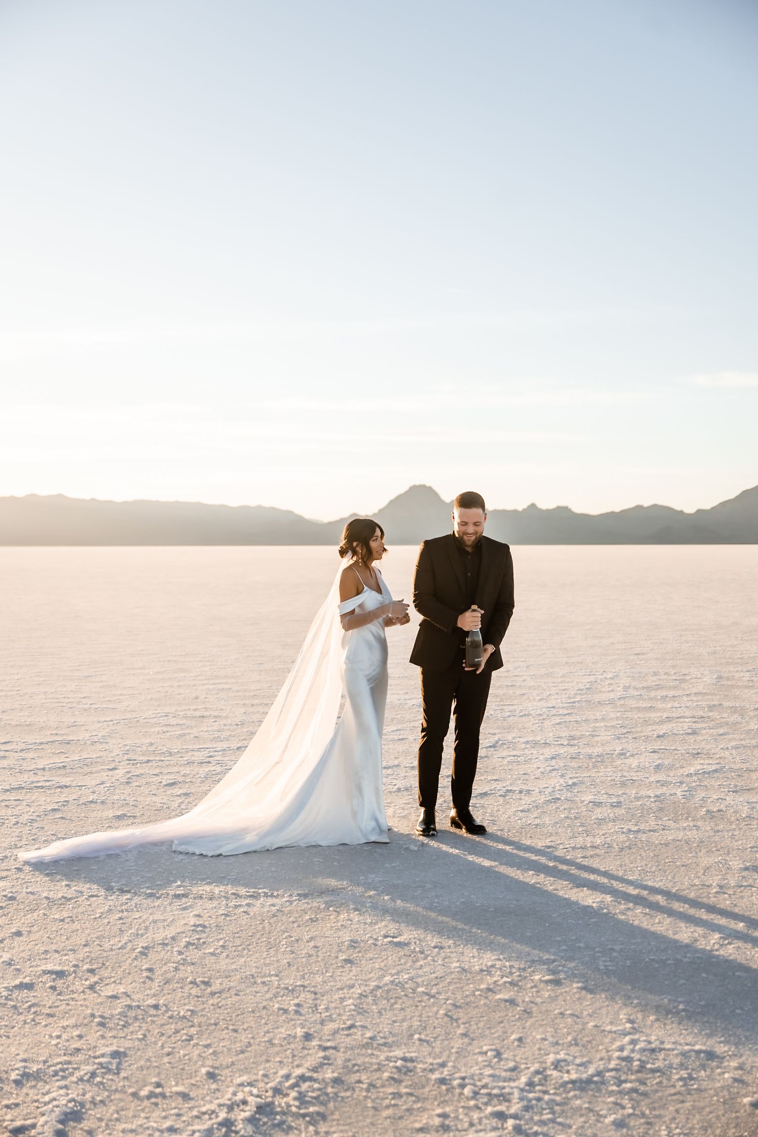 Couple shares intimate wedding ceremony moments on bright salt flats.