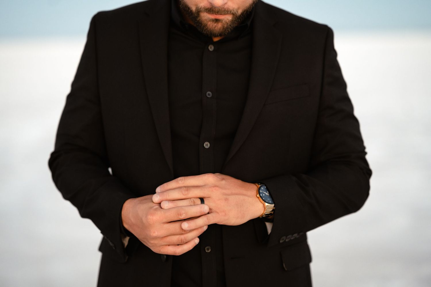 Close-up details of a formal black suit and tie.