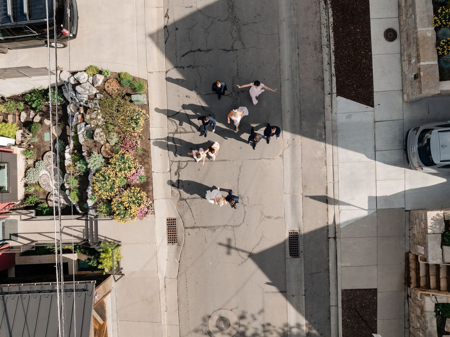 Wedding party poses on steep urban street with mountain views in background.