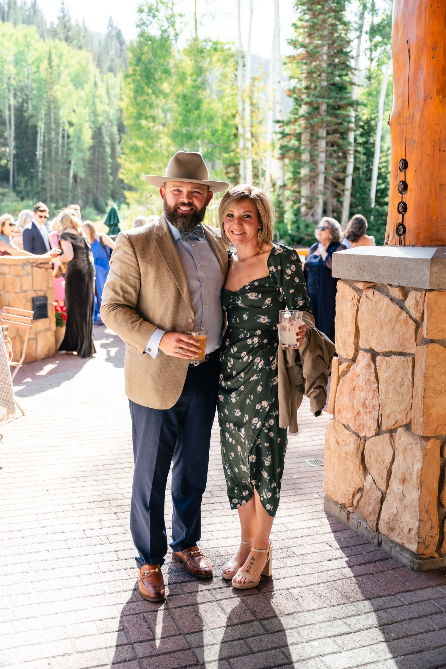 Couple sharing intimate moments against rustic stone pillars during an outdoor photo session.