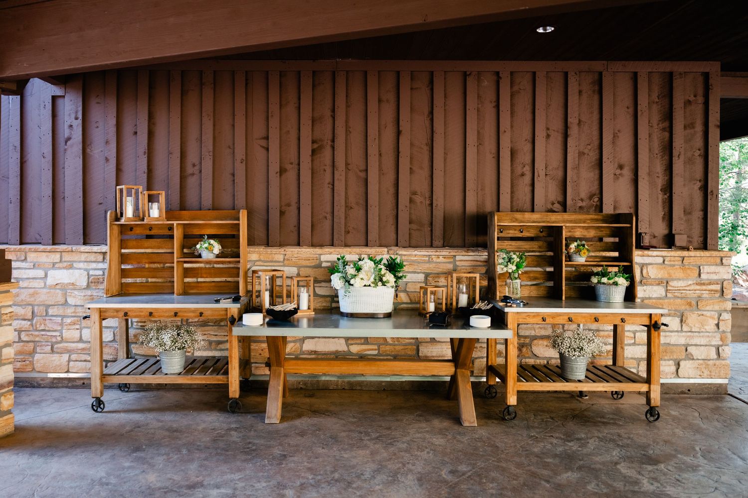 Rustic wooden display setup with vintage crates and benches against brick and wood wall for wedding decor.