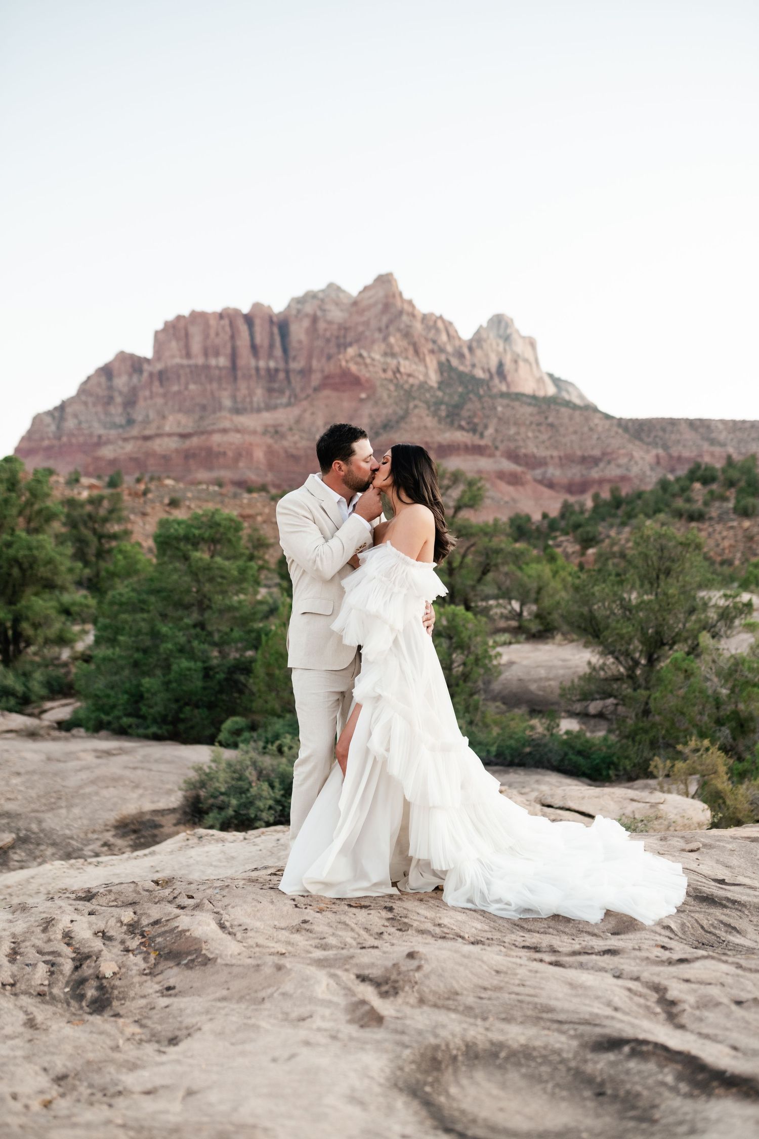 Zion Adventure Session. Wedding photos captured on desert rocks with dramatic red cliffs in the background.
