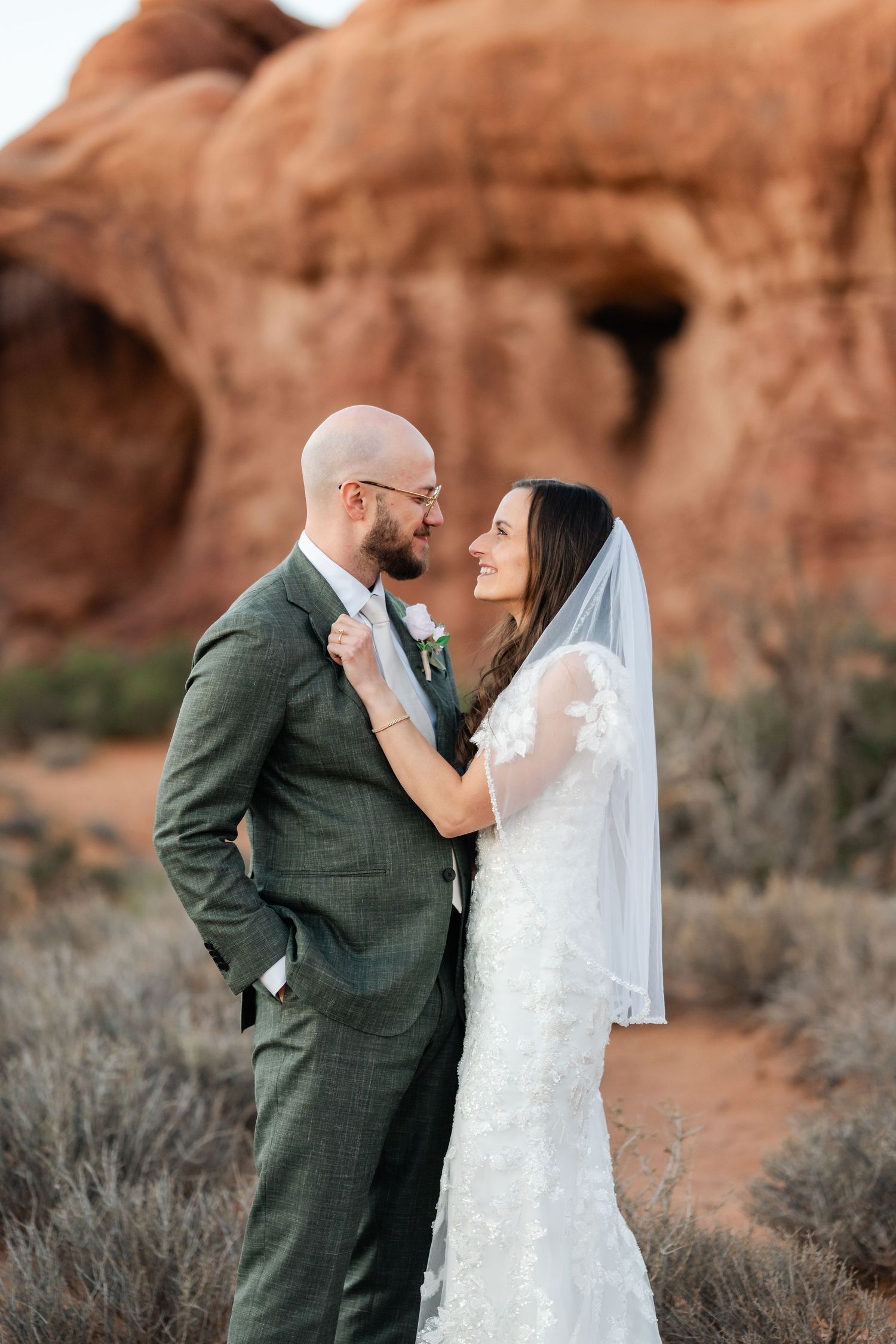 Romantic wedding portraits captured against rustic desert landscape with red rock formations.