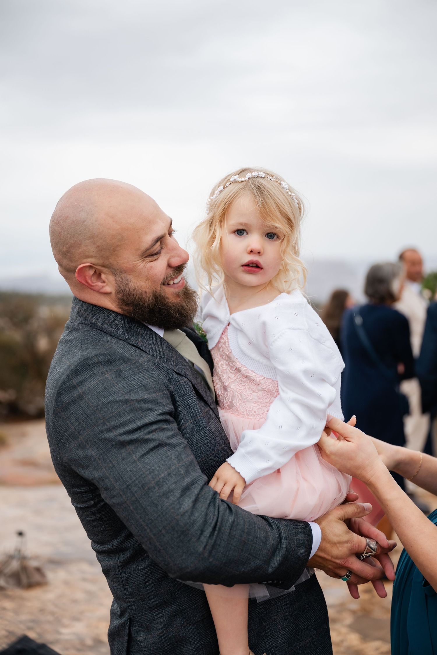 A sequence of tender moments between a father and young child in casual attire against an outdoor backdrop.