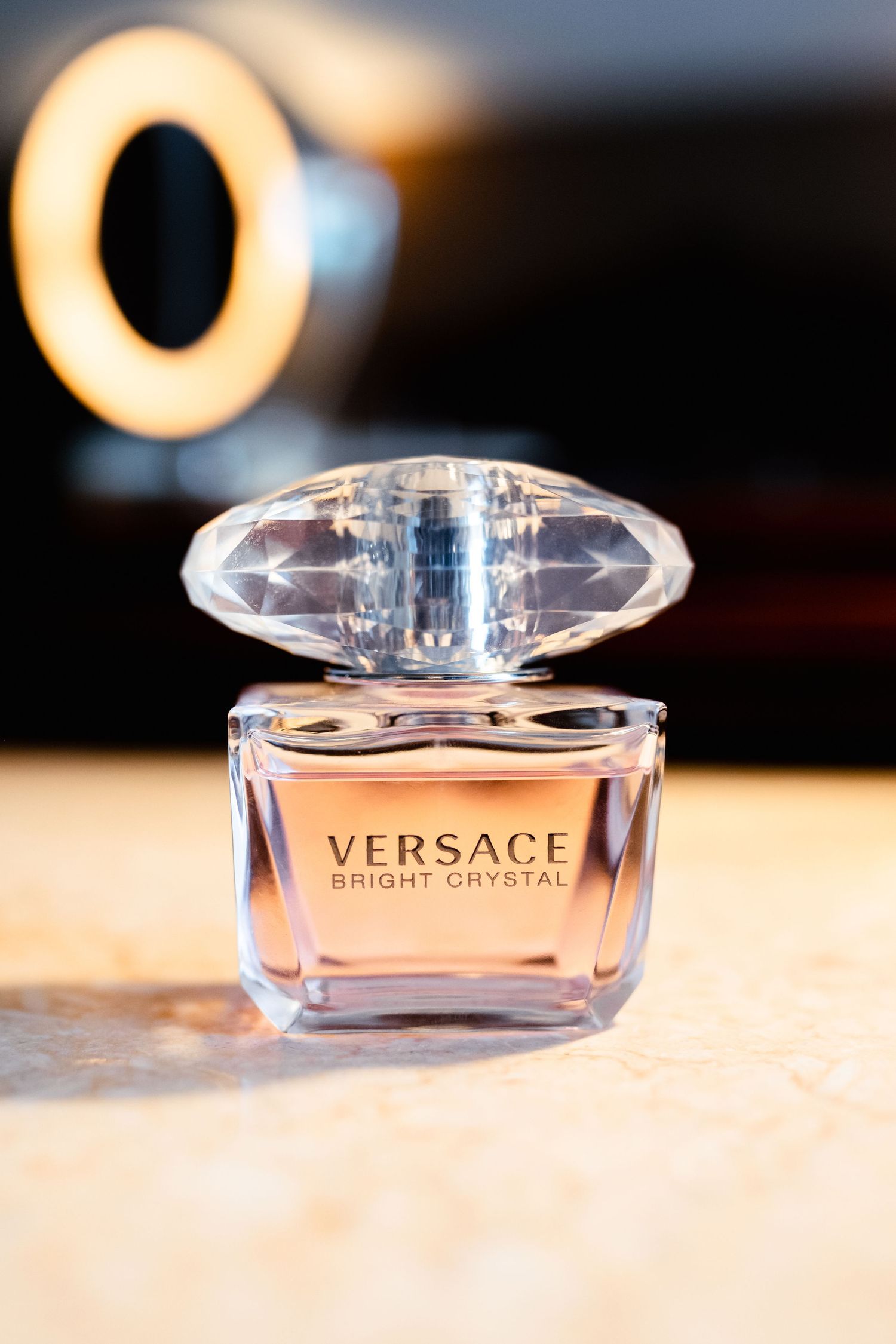 Versace Bright Crystal perfume bottle displayed on a beige surface.