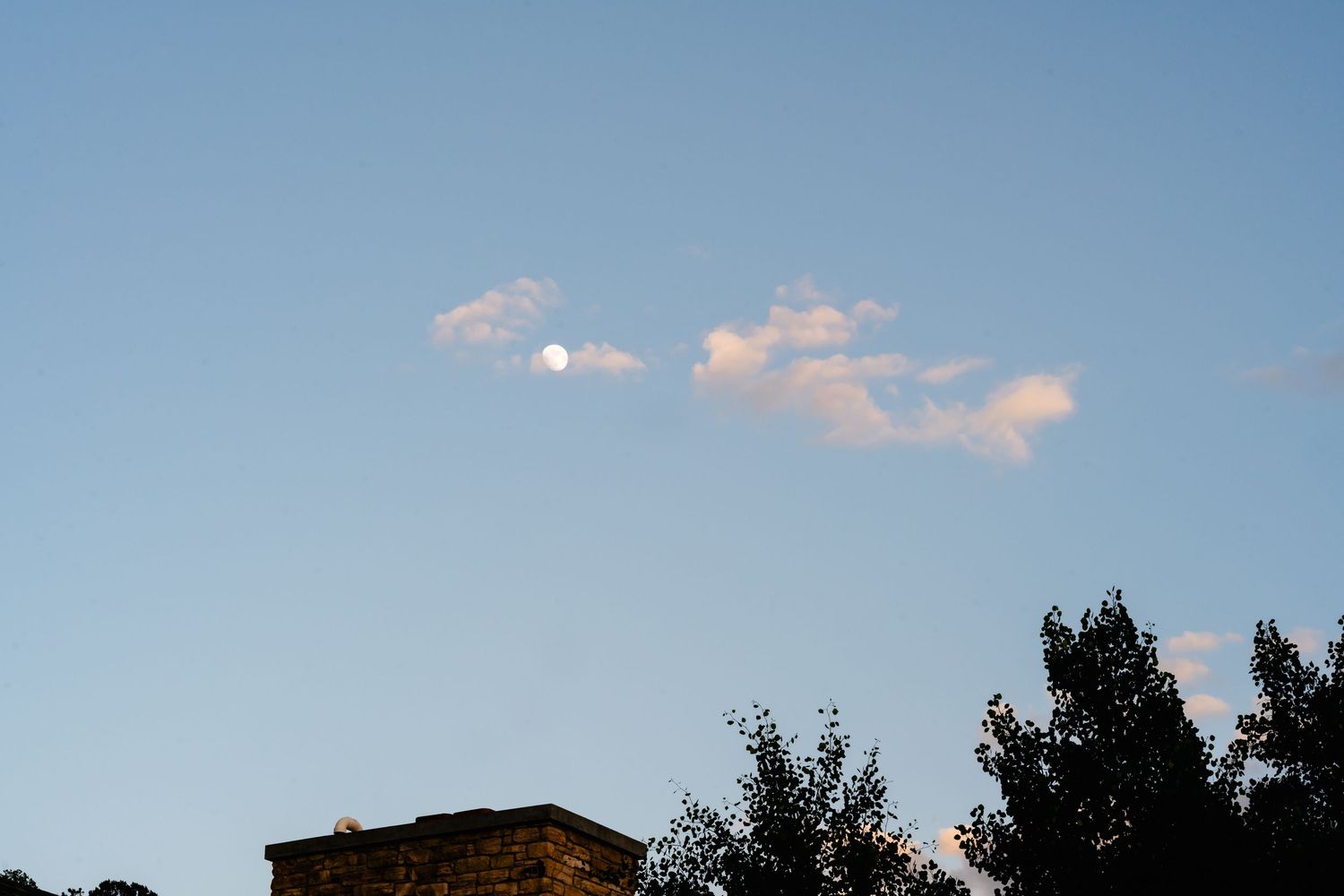 Peaceful blue sky with wispy clouds during golden hour.