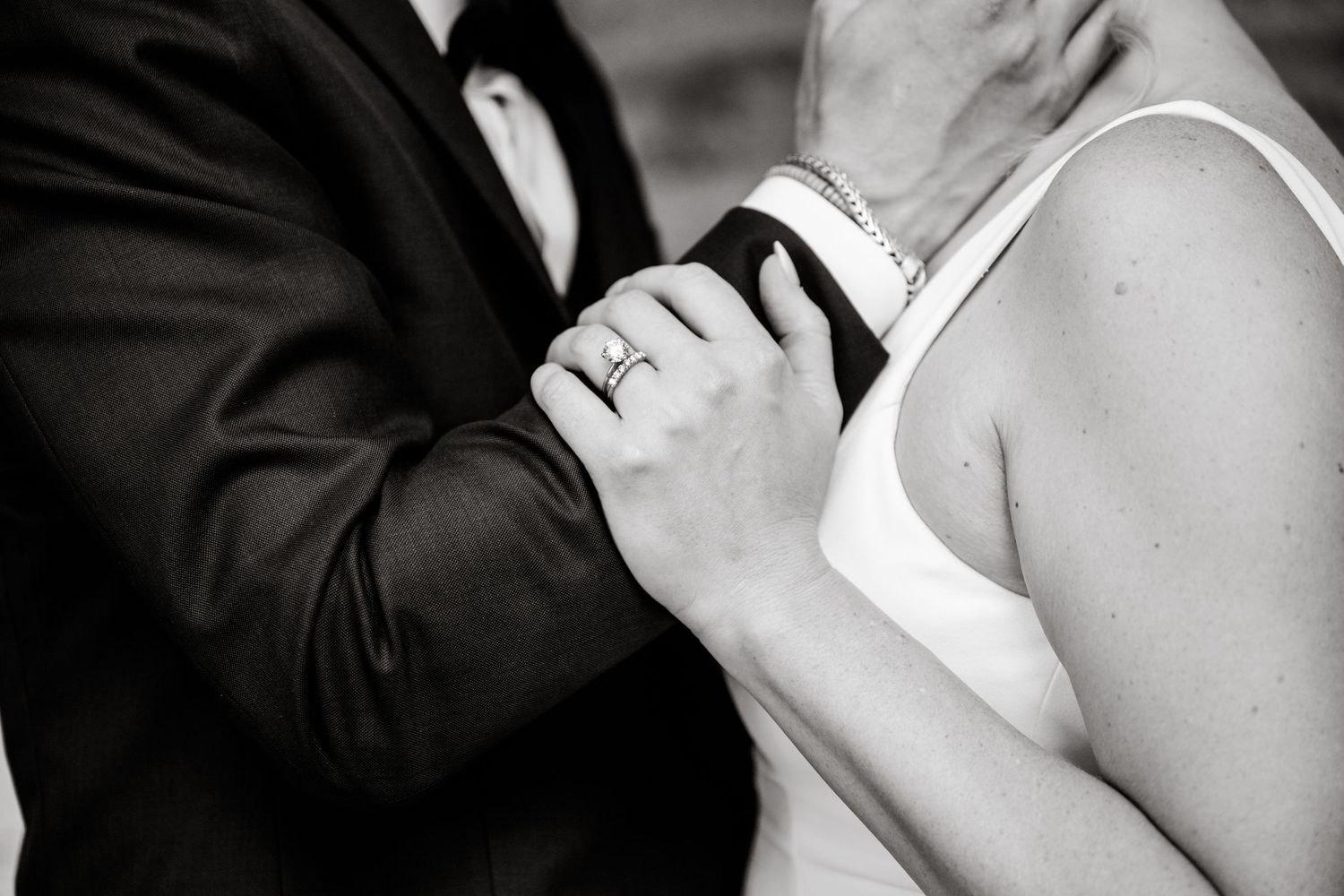 Black and white wedding photos showing intimate moments between a couple in formal attire.