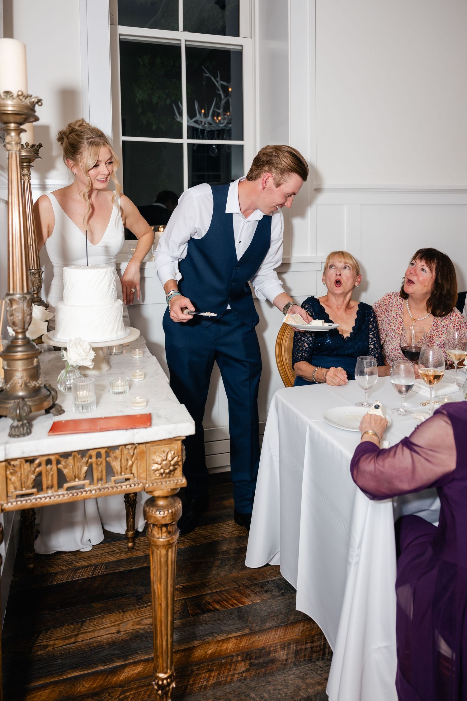 Guests share laughter and conversation around elegant tables at a wedding reception.