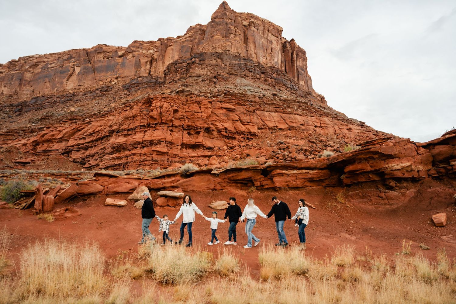 Panoramic view of red sandstone cliffs and desert landscape in Monument Valley during sunset.
