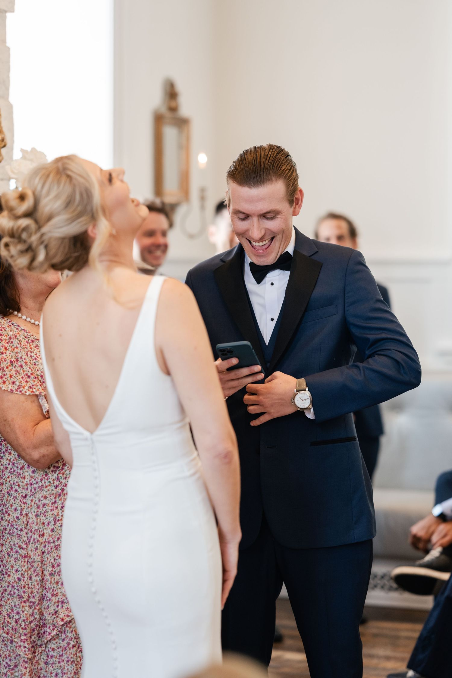Smiling groom shares a joyful moment with bride in white backless gown during wedding ceremony at their wedding weekend in Park City