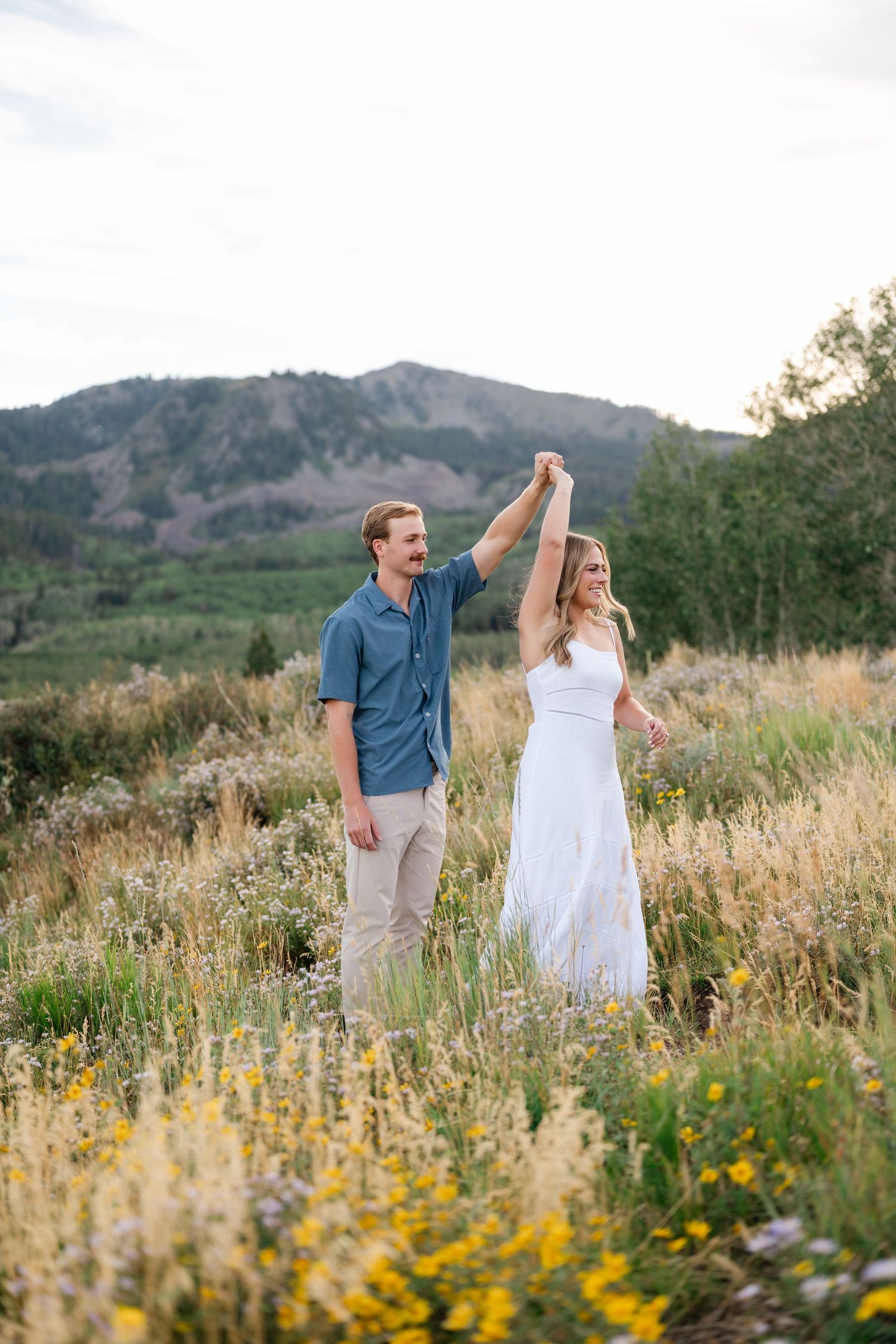 Couple dancing in a wildflower meadow with mountain views near Deer Valley and Park City.