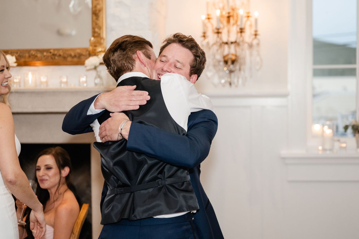 Couples dancing together at elegant wedding reception with chandeliers.