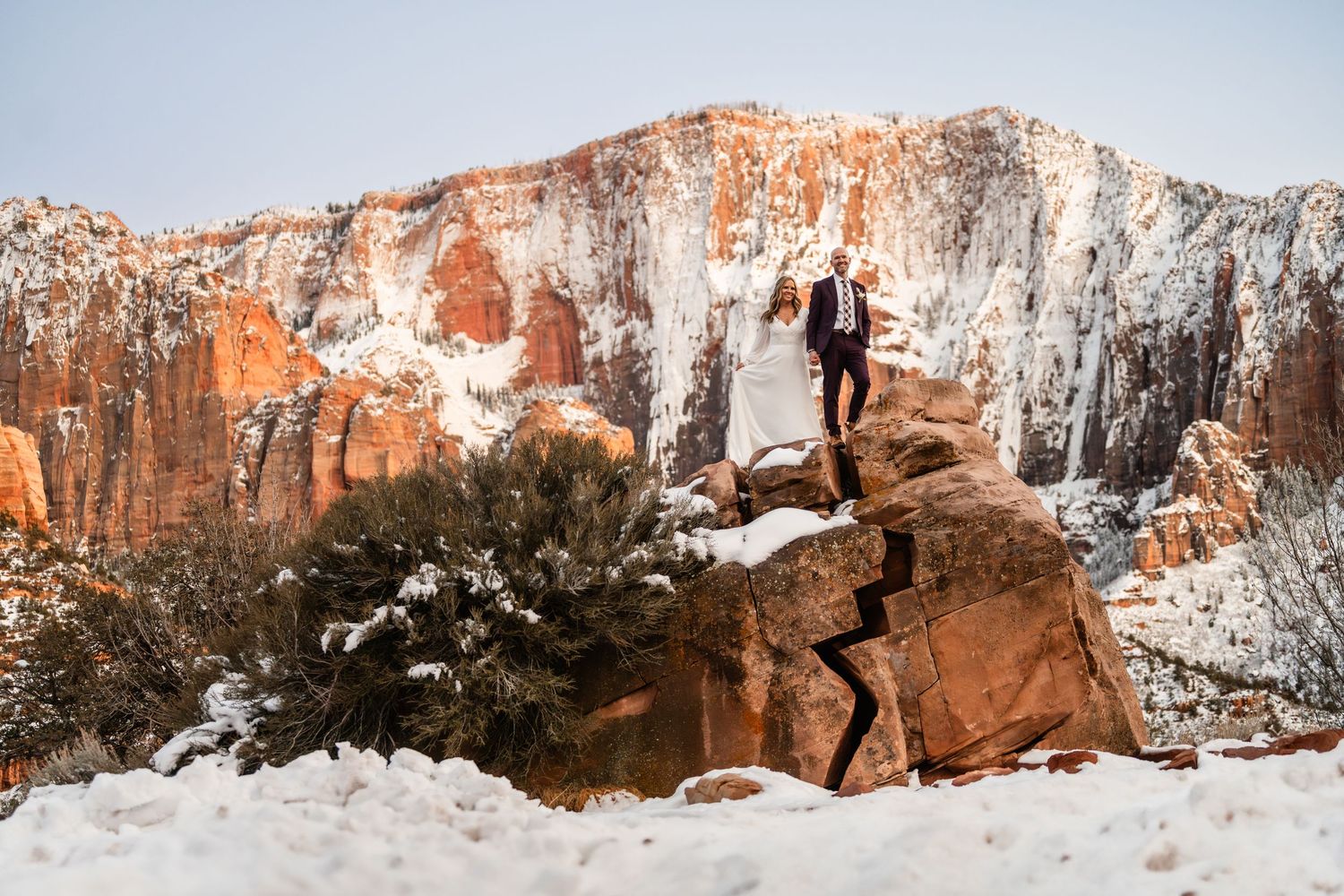 Winter panorama of snow-dusted red rock cliffs and canyons in Zion National Park.
