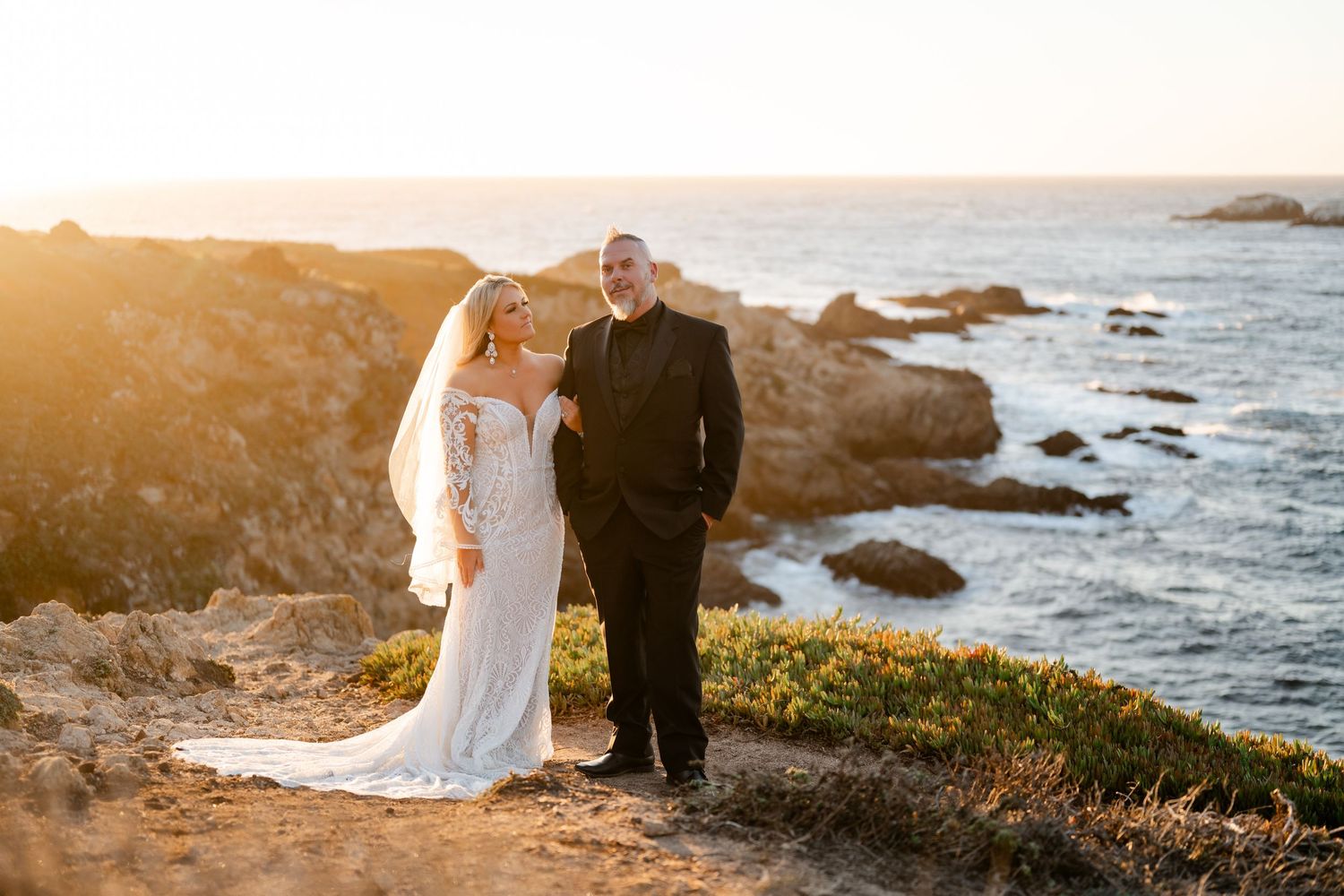 Golden sunset illuminates rocky coastline during wedding photography session.