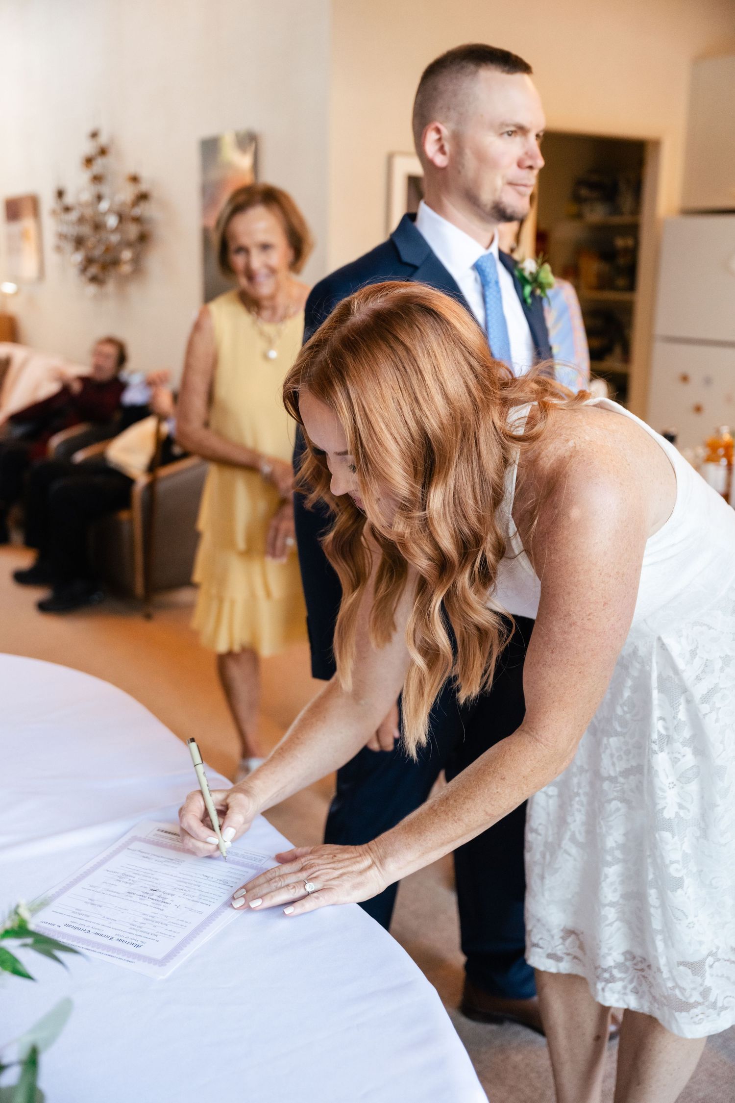 Series of wedding guests signing the guestbook at an indoor reception venue.