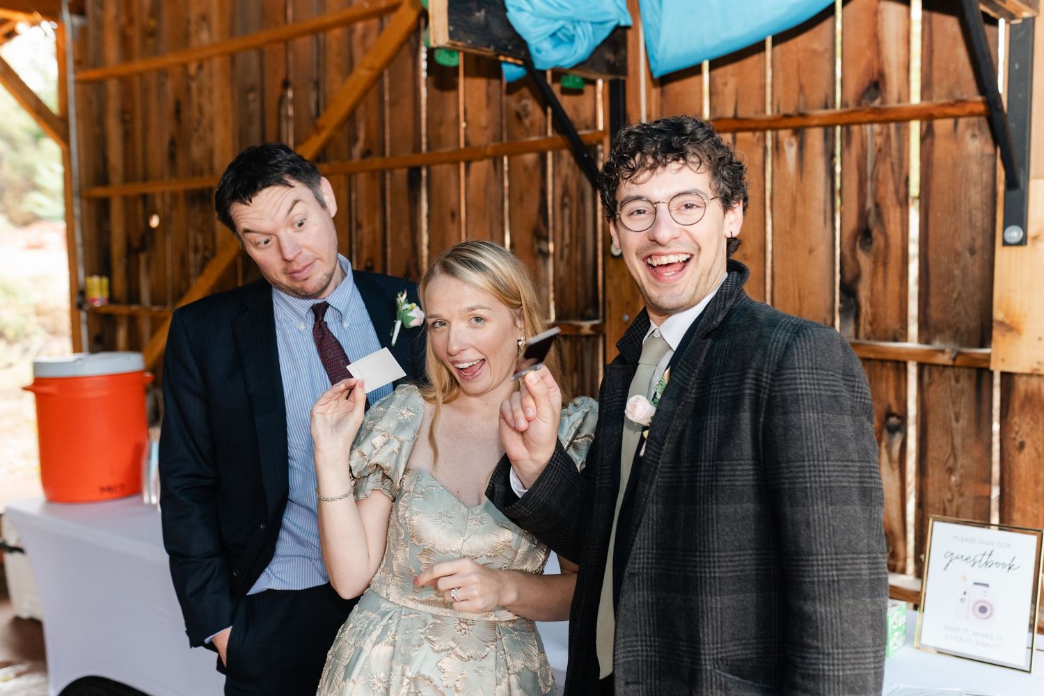 Wedding celebration inside a rustic barn venue with wooden beams and decorative lighting.