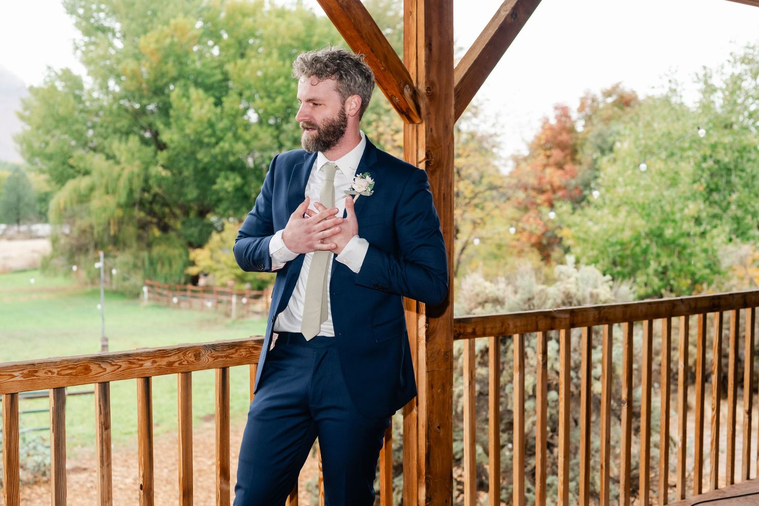 Wedding celebration on a wooden deck overlooking autumn trees and landscape.
