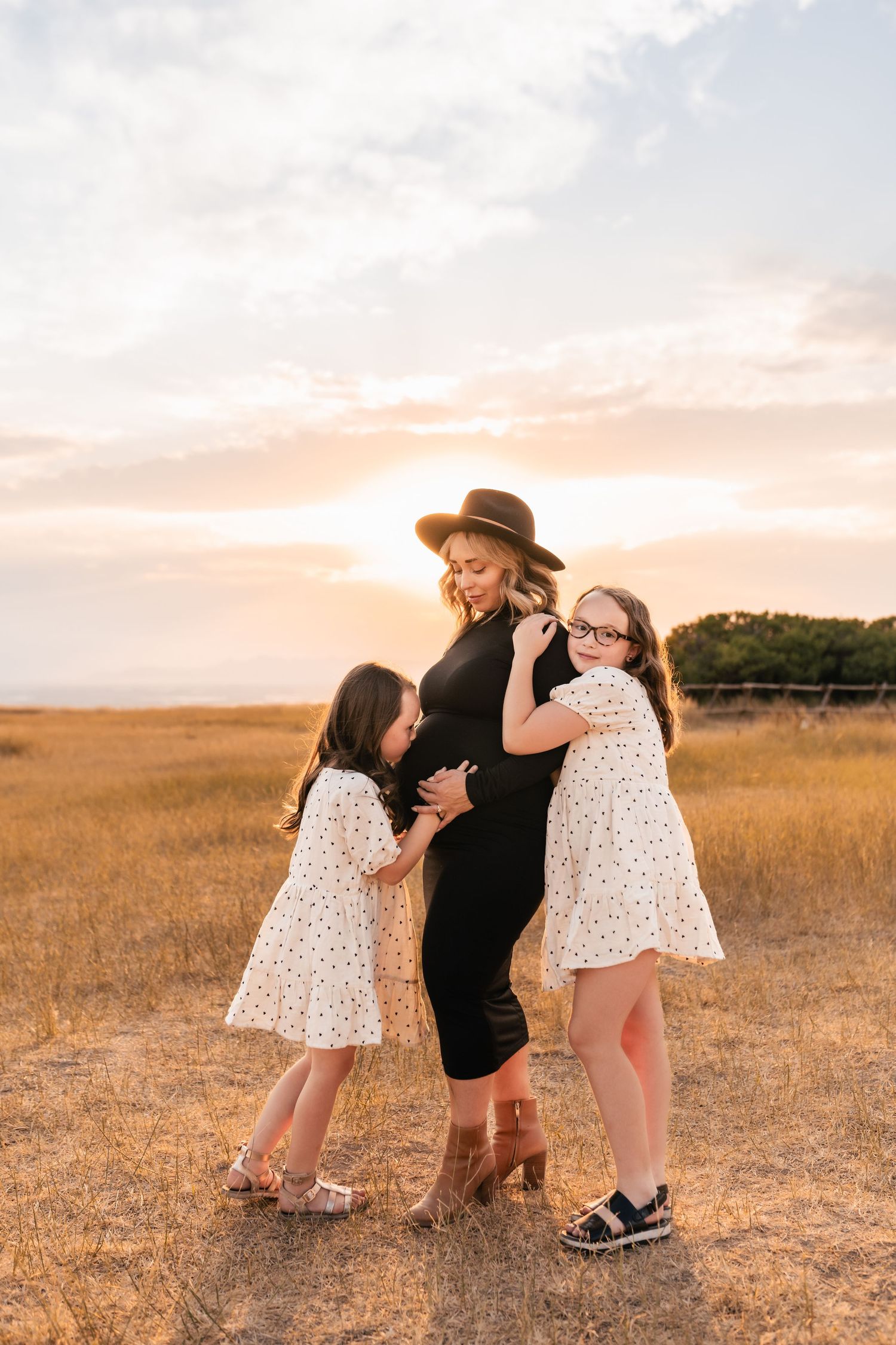 Sweet family moments captured in a sun-drenched field during golden hour.