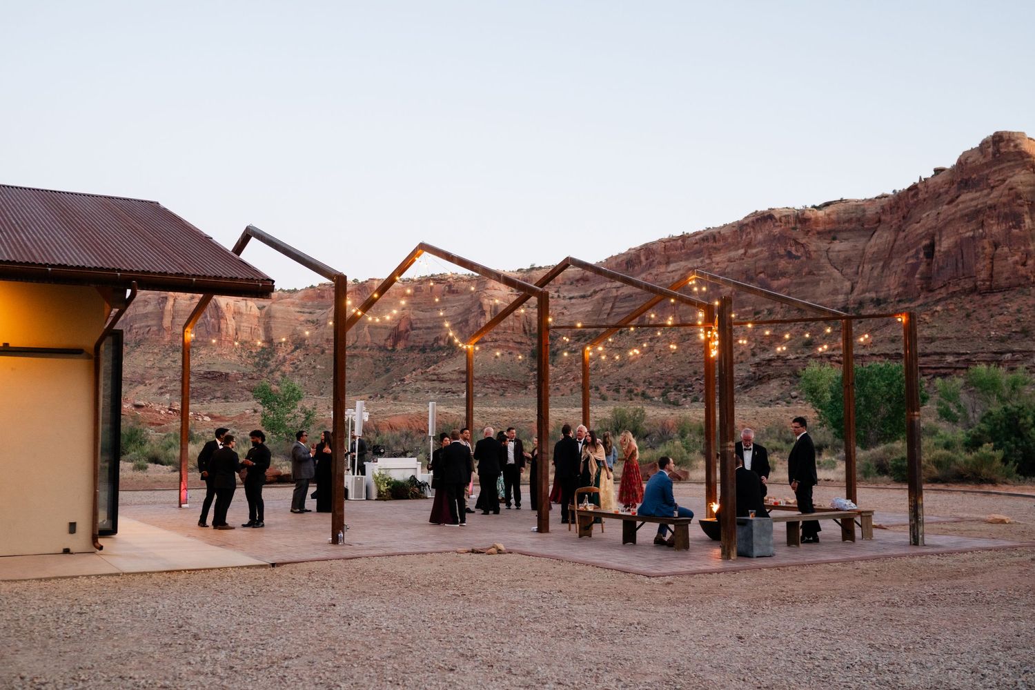 Outdoor wedding reception under string lights at Red Earth Venue. Dancing at dusk.