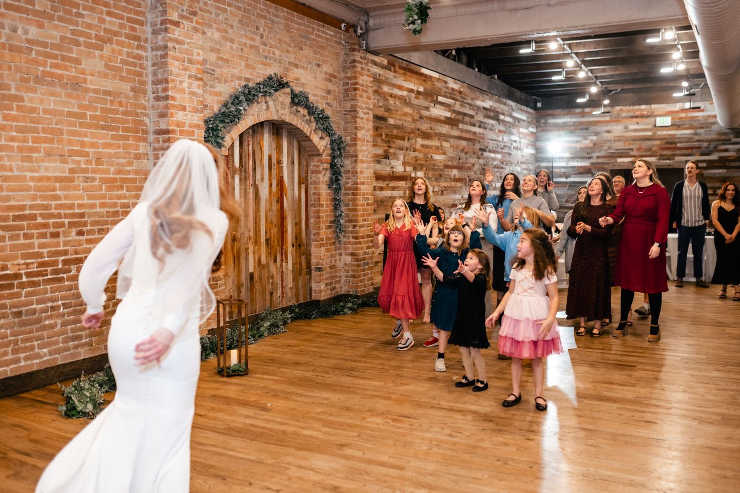 A celebration taking place in an indoor venue with exposed brick walls as guests gather for festivities.