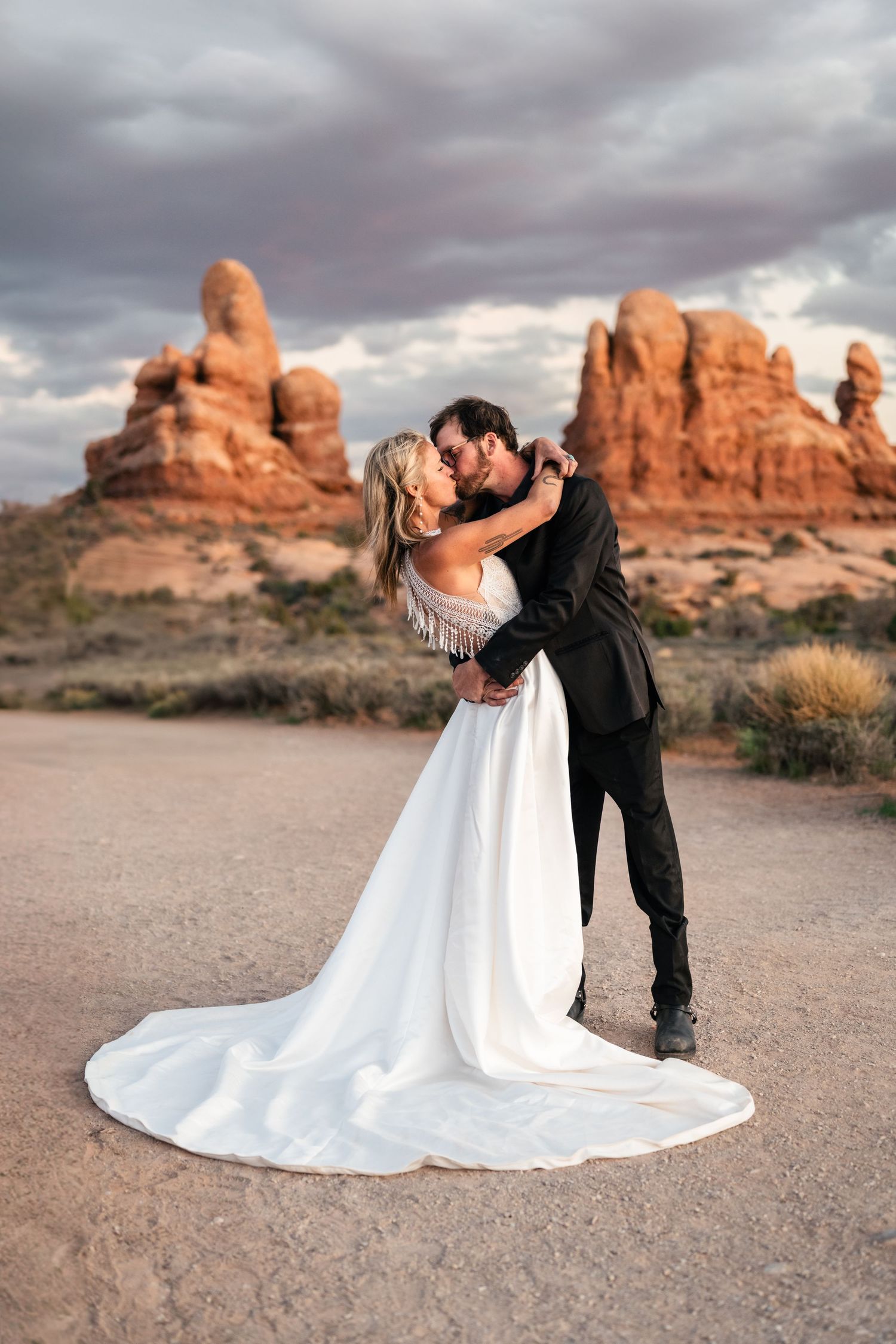 Wedding couple kiss at Arches National park by Arches Wedding Photographer