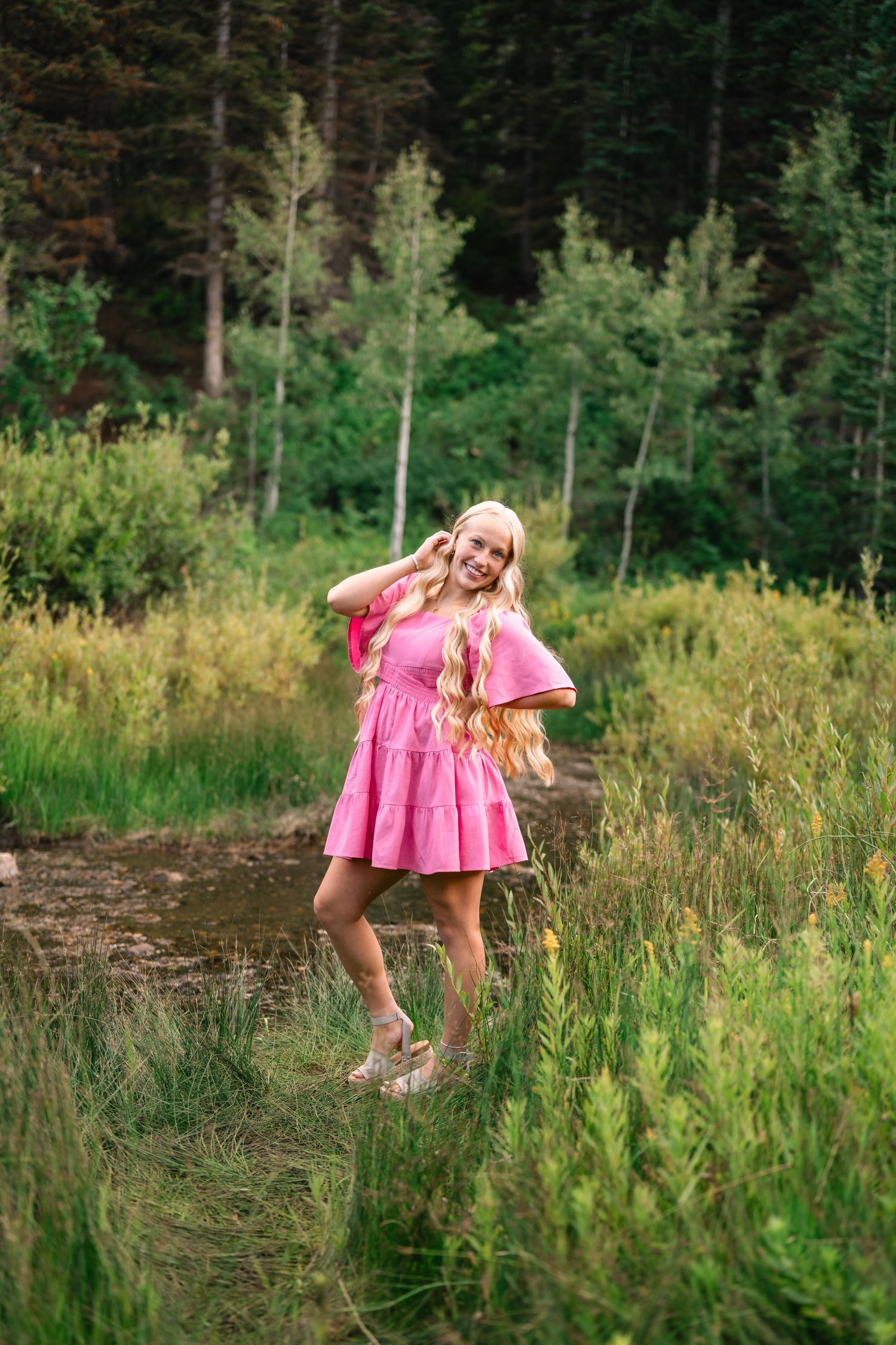 senior girl smiling down her shoulder during her mountain senior session