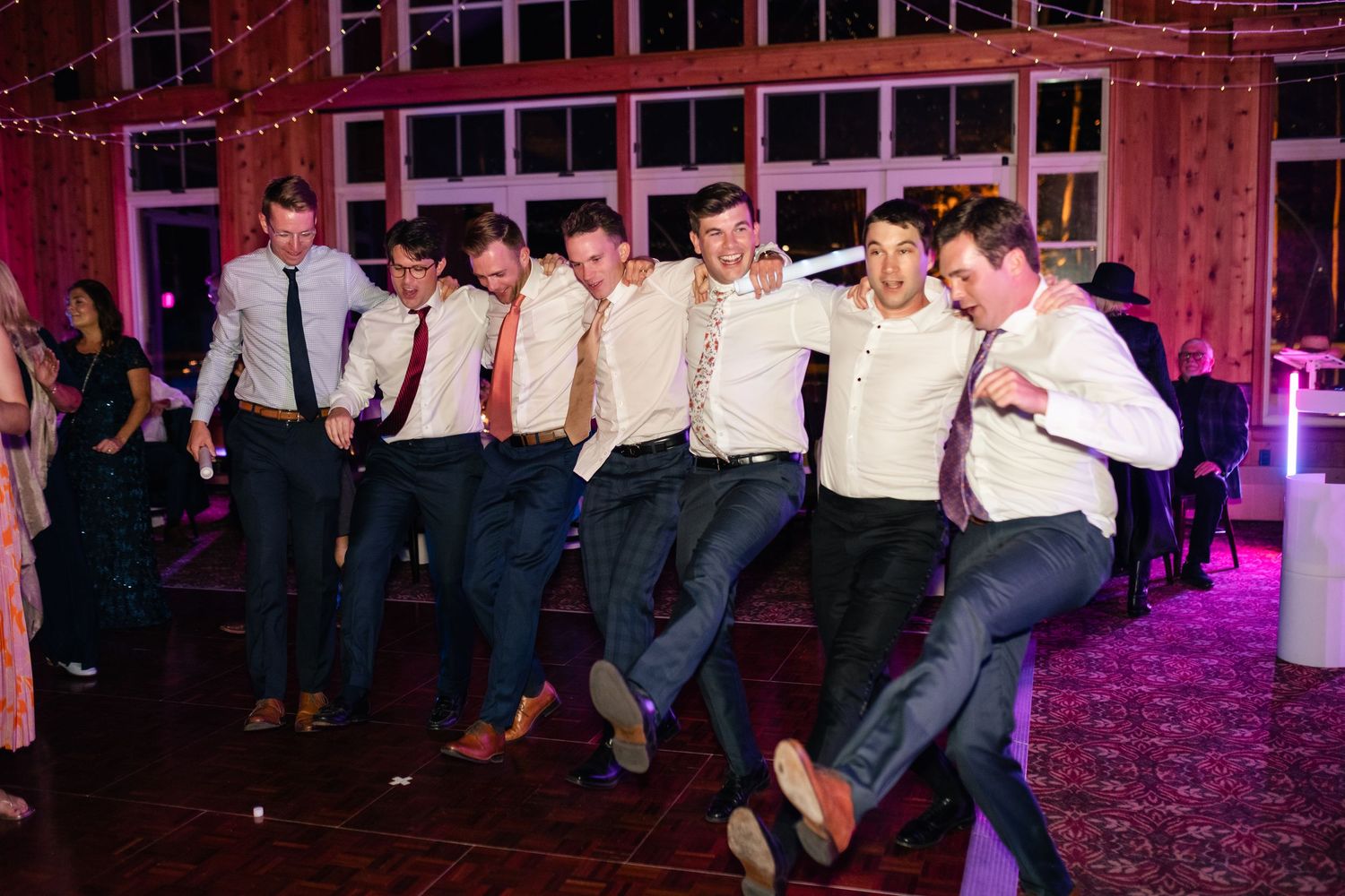 Groomsmen performing choreographed dance routine at wedding reception.