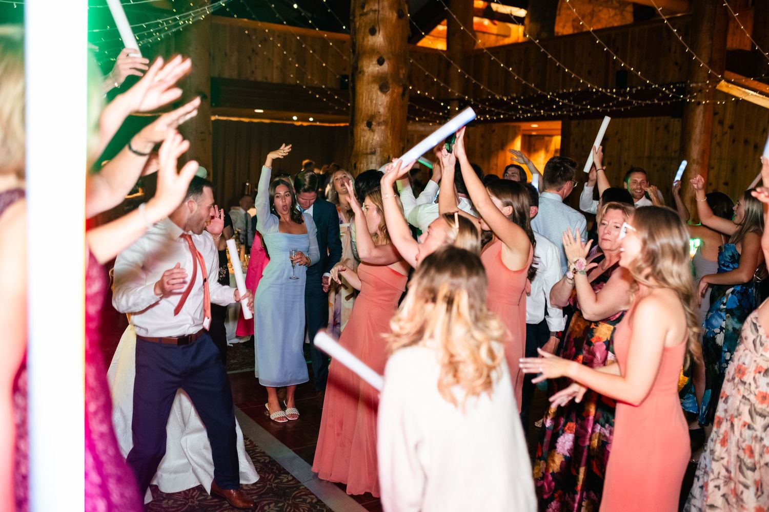 Wedding guests dance and celebrate on a lively reception dance floor.