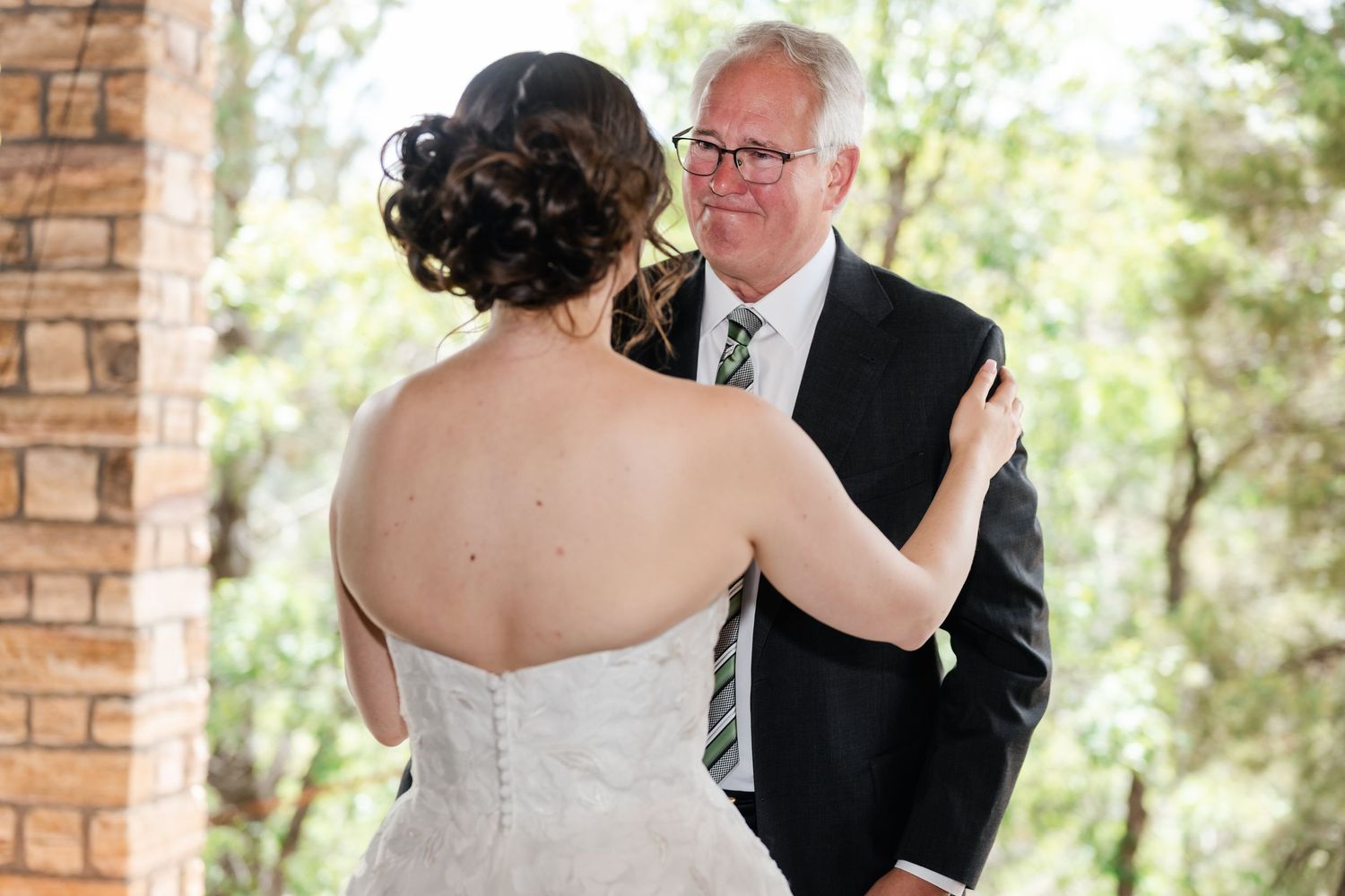 A couple shares intimate moments during their first look at an outdoor wedding venue.