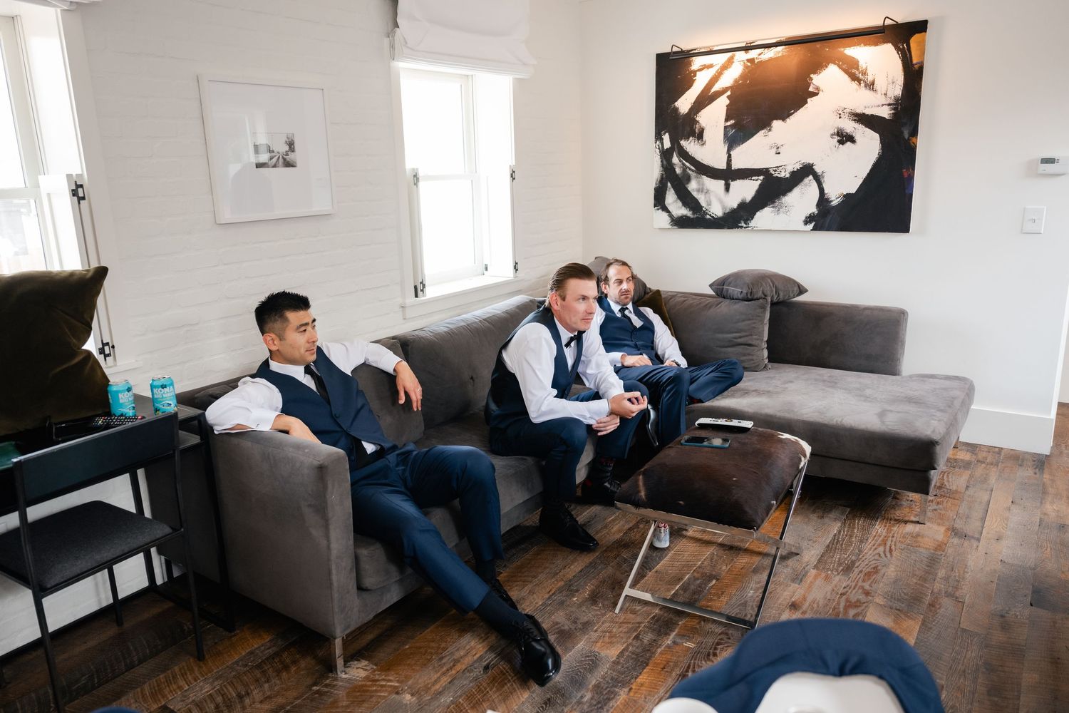 Two people relaxing on gray modern couches in a contemporary living room setting.