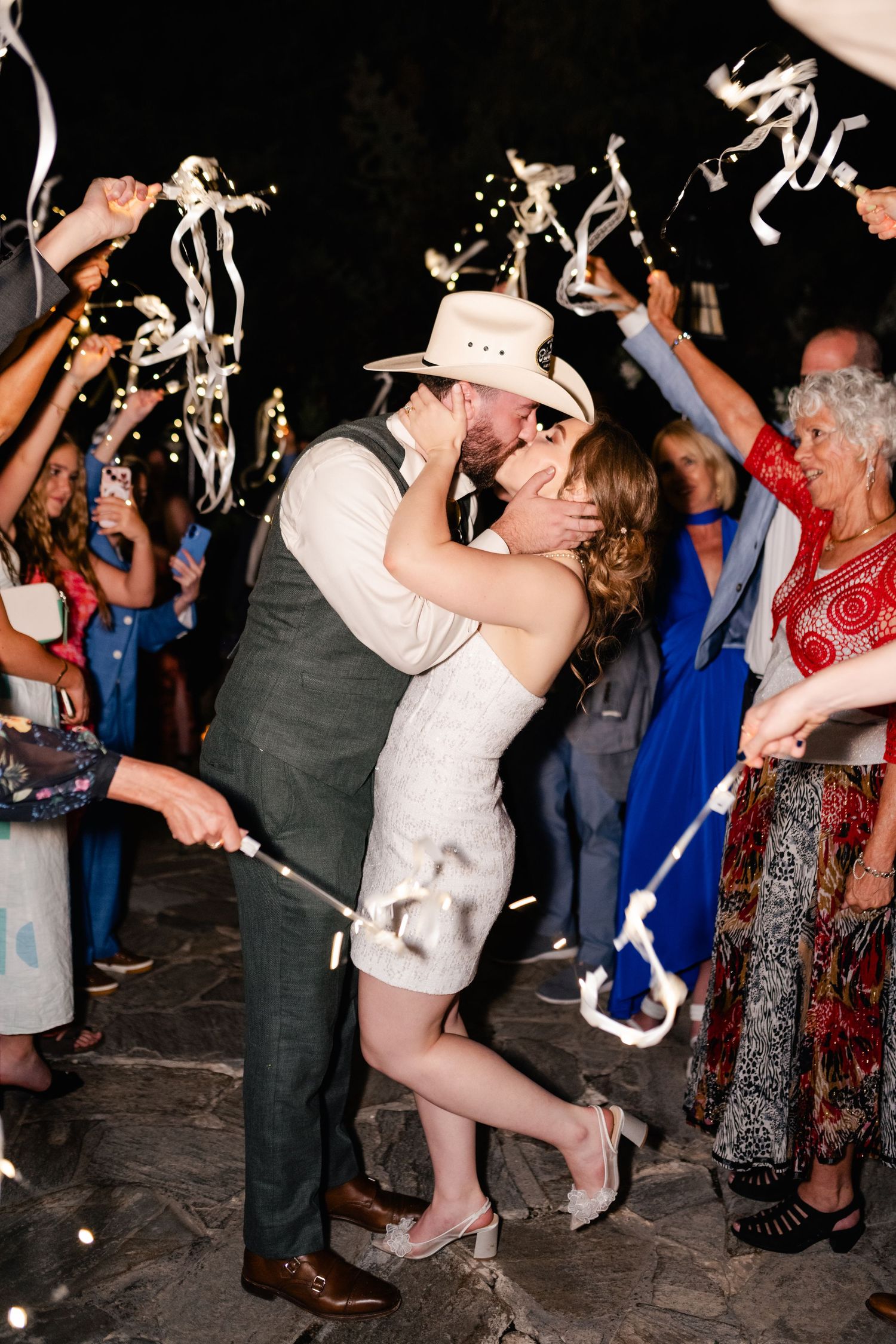 Wedding reception guests dancing and celebrating with sparklers at night creating a festive atmosphere. Millcreek Inn Wedding Photographer.