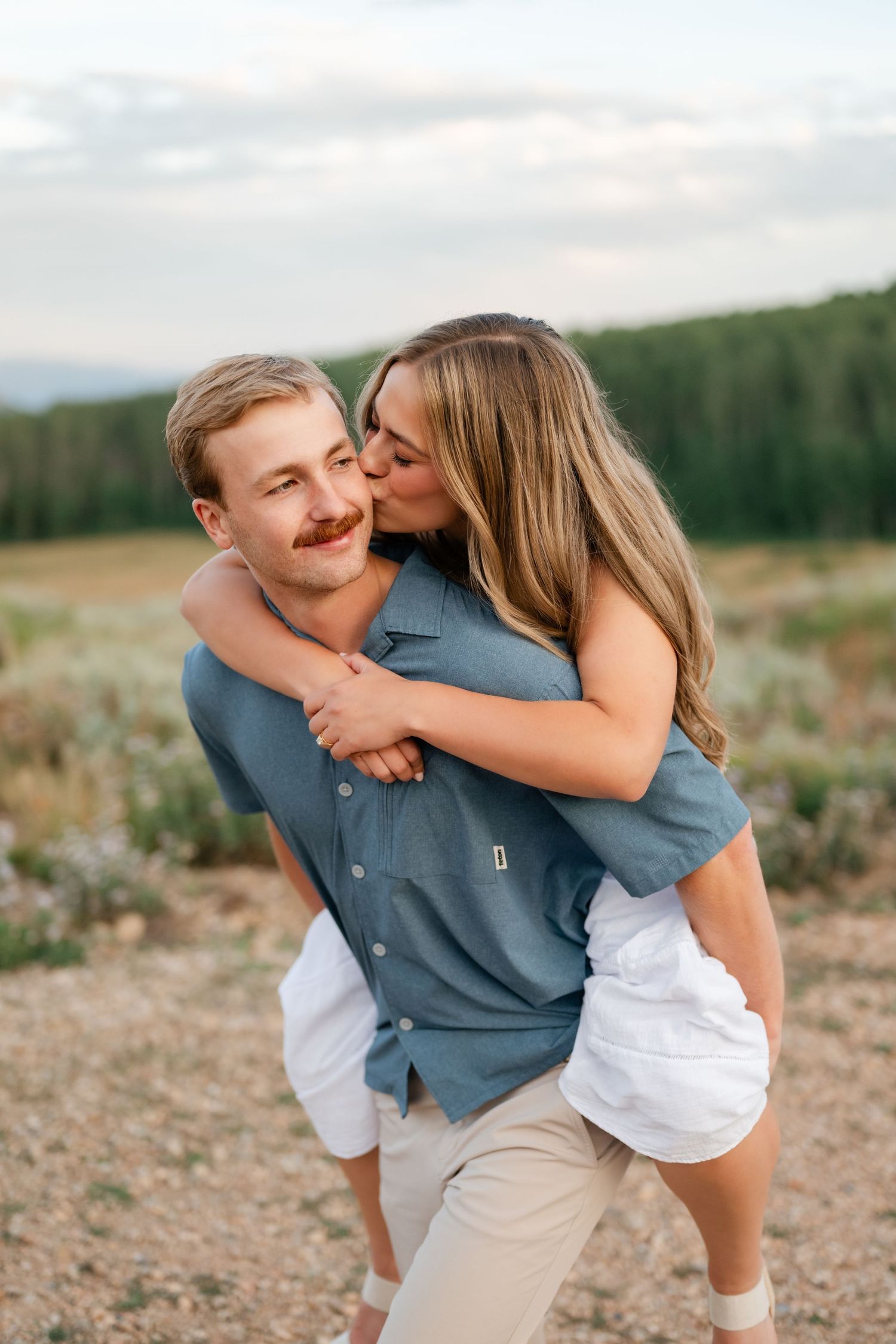 A woman kisses a man on the cheek while he gives her a piggyback ride near Deer Valley and Park City.