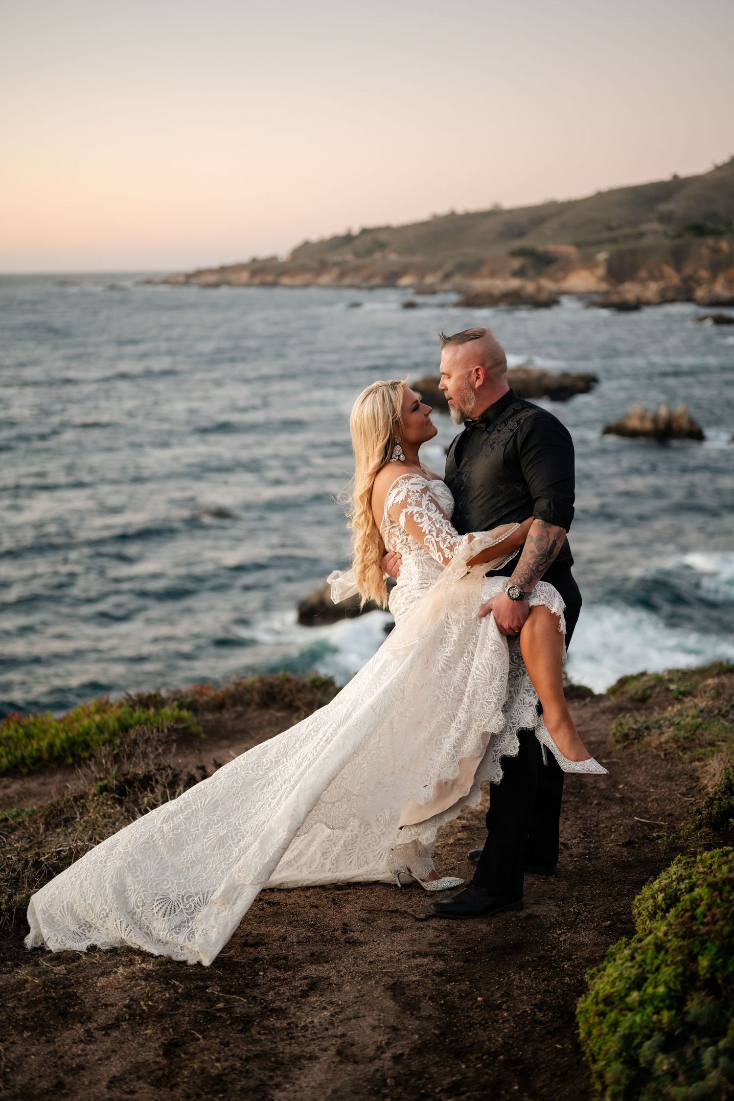A couple dances and twirls on a seaside cliff during their sunset wedding photo session.